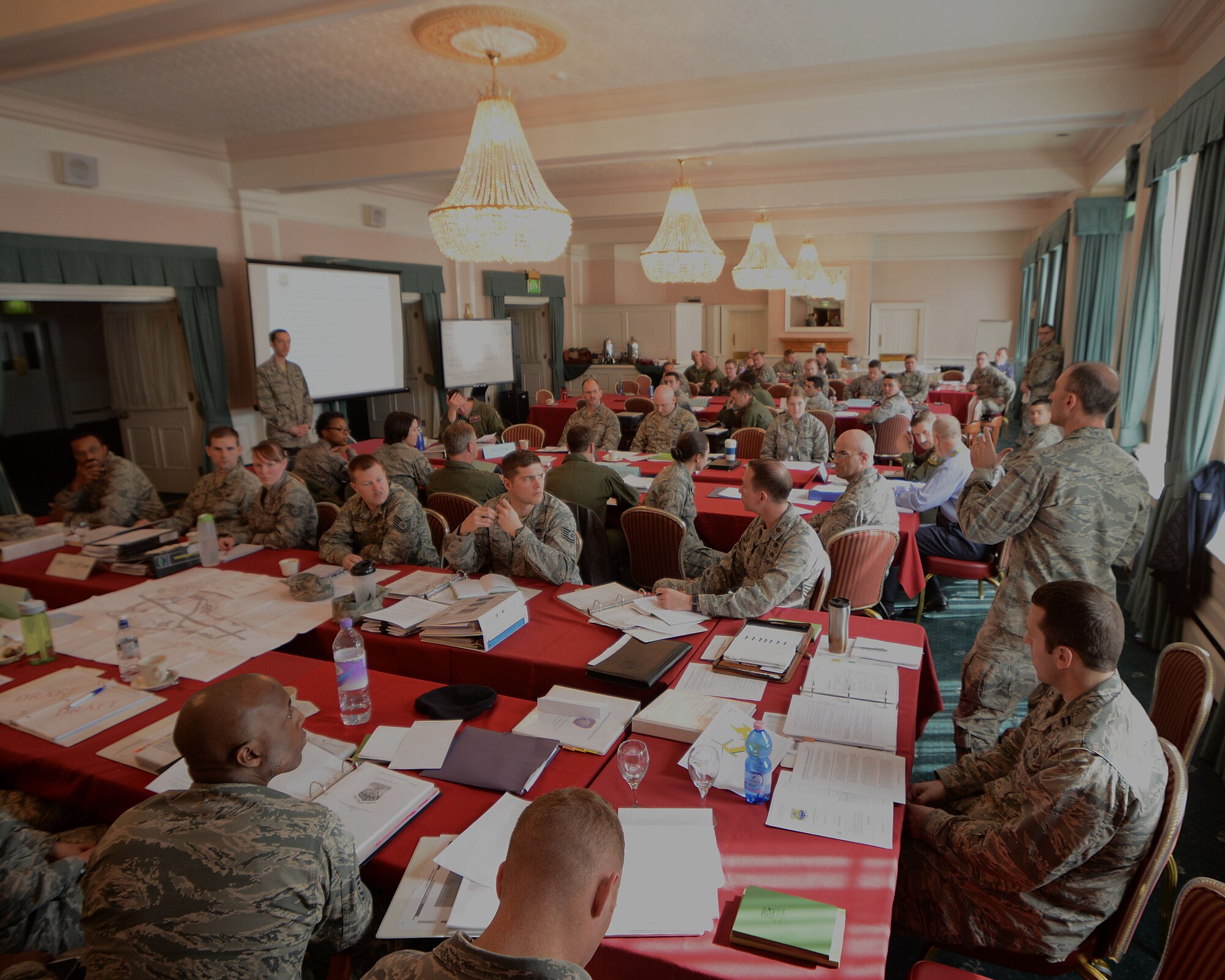 Team Mildenhall members discuss simulated responses during a tabletop exercise March 25, 2014, on RAF Mildenhall, England. Representatives from different agencies practice coordinating responses to mock emergencies during tabletop exercises. This style of training allows RAF Mildenhall to be ready without using as many personnel as a standard exercise. (U.S. Air Force photo by Airman 1stClass Preston Webb/Released)