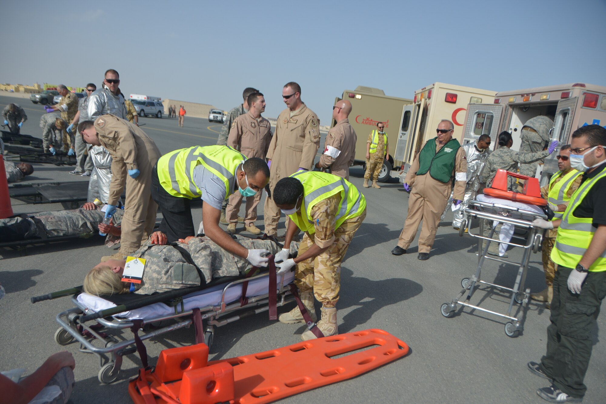 Qatar Emiri Air Force first responders prepare to transport a simulated patient on a litter during a base-wide Major Accident Response Exercise at Al Udeid Air Base, Qatar, March 21, 2014. The simulated scenario for the MARE involved a C-130 Hercules which crashed at the end of a runway with 20 service members onboard. Organizations from all over the base including host nation counterparts had to react to the exercise as if it were the real deal. (U.S. Air Force photo/Senior Airman Jared Trimarchi) 