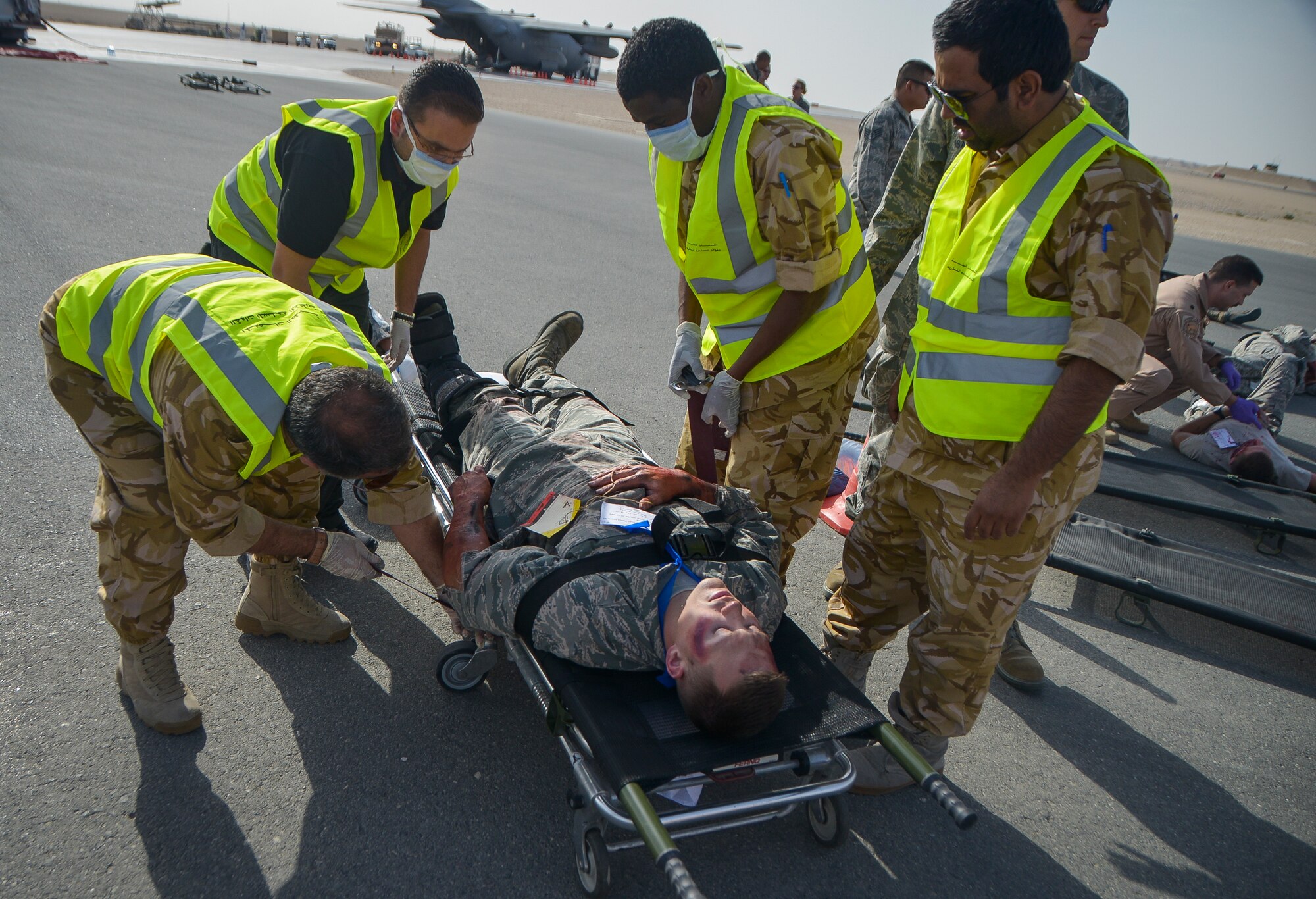 Qatar Emiri Air Force first responders prepare to transport a simulated patient on a litter during a base-wide Major Accident Response Exercise at Al Udeid Air Base, Qatar, March 21, 2014. The simulated scenario for the MARE involved a C-130 Hercules which crashed at the end of a runway with 20 service members onboard. Organizations from all over the base including host nation counterparts had to react to the exercise as if it were the real deal. (U.S. Air Force photo/Senior Airman Jared Trimarchi) 