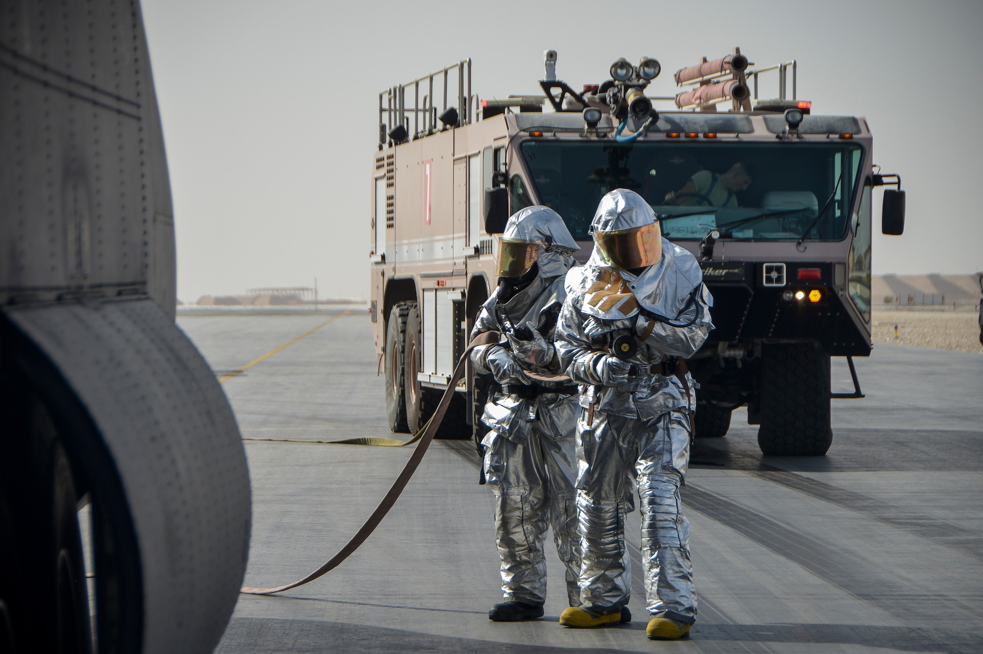 Firemen from the 379th Expeditionary Civil Engineer Squadron fire protection flight simulate putting out a aircraft fire during a base-wide Major Accident Response Exercise at Al Udeid Air Base, Qatar, March 21, 2014. The simulated scenario for the MARE involved a C-130 Hercules which crashed at the end of a runway with 20 service members onboard. Organizations from all over the base including host nation counterparts had to react to the exercise as if it were the real deal. (U.S. Air Force photo/Senior Airman Jared Trimarchi) 
