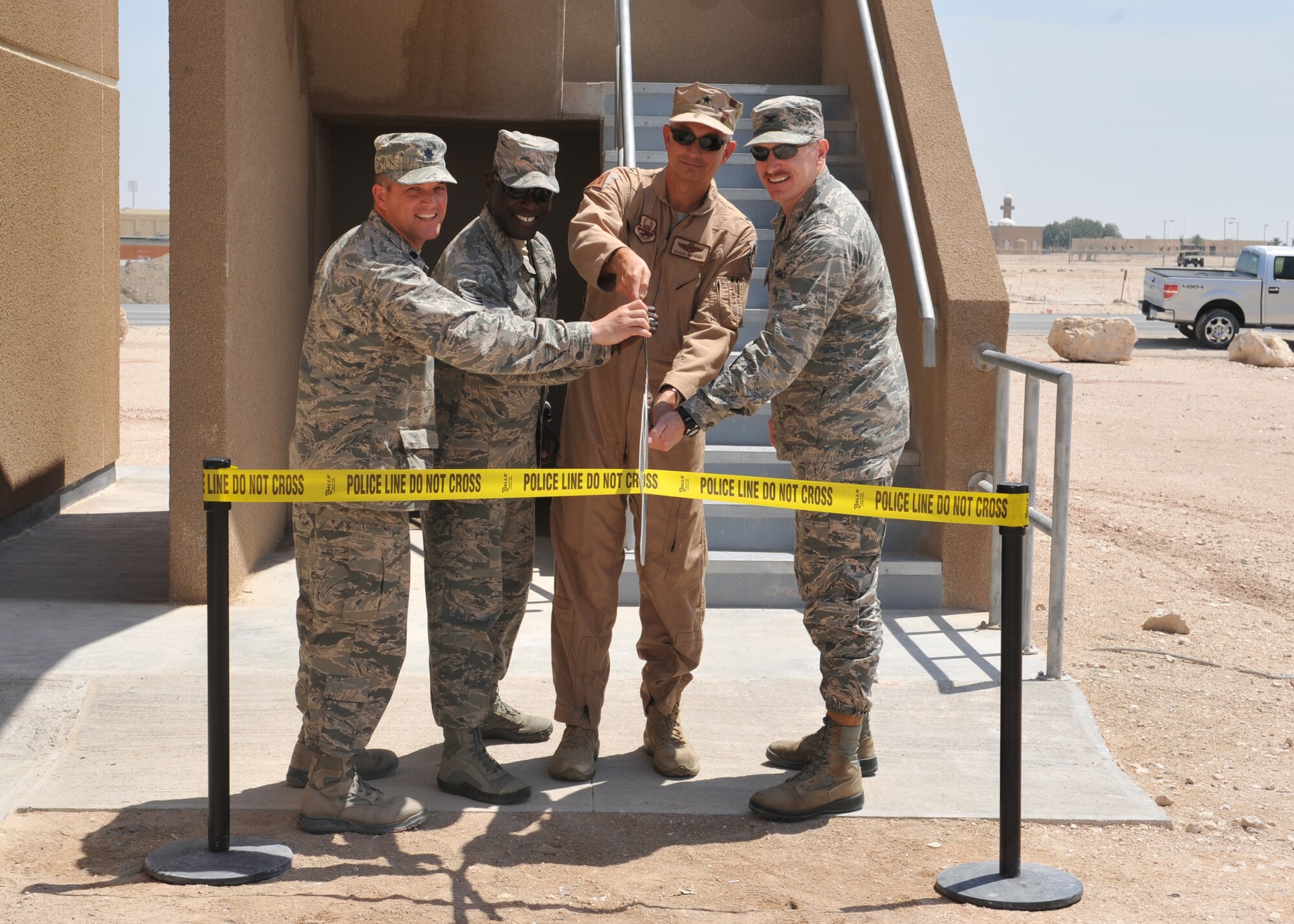 Senior leaders from the 379th Air Expeditionary Wing cut the ceremonial ribbon formally opening the newest 379th Expeditionary Security Forces Squadron facility at Udeid Air Base, Qatar, Mar. 28, 2014. The new building will provide Air Force members and contractors with new work space to train newly assigned security forces personnel, Qatar Emiri Air Forces and QEAF military police. (U.S. Air Force photo by Master Sgt. David Miller)