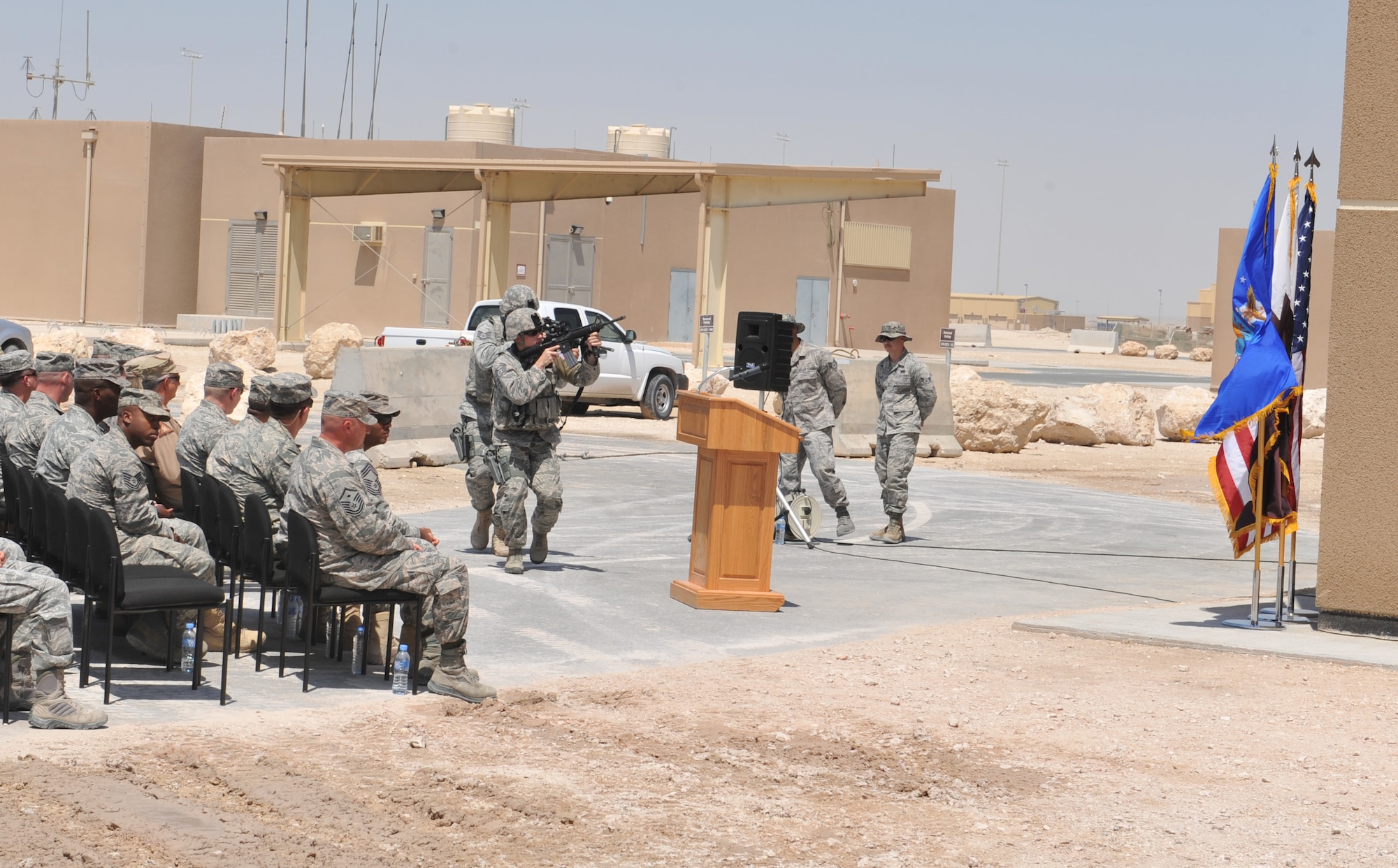 Members of 379th Air Expeditionary Wing watch a security forces building clearing demonstration prior to the formal opening of the newest 379th Expeditionary Security Forces Squadron facility at Udeid Air Base, Qatar, Mar. 28, 2014. The new building will provide Air Force members and contractors with new work space to train newly assigned security forces personnel, Qatar Emiri Air Forces and QEAF military police. (U.S. Air Force photo by Master Sgt. David Miller)