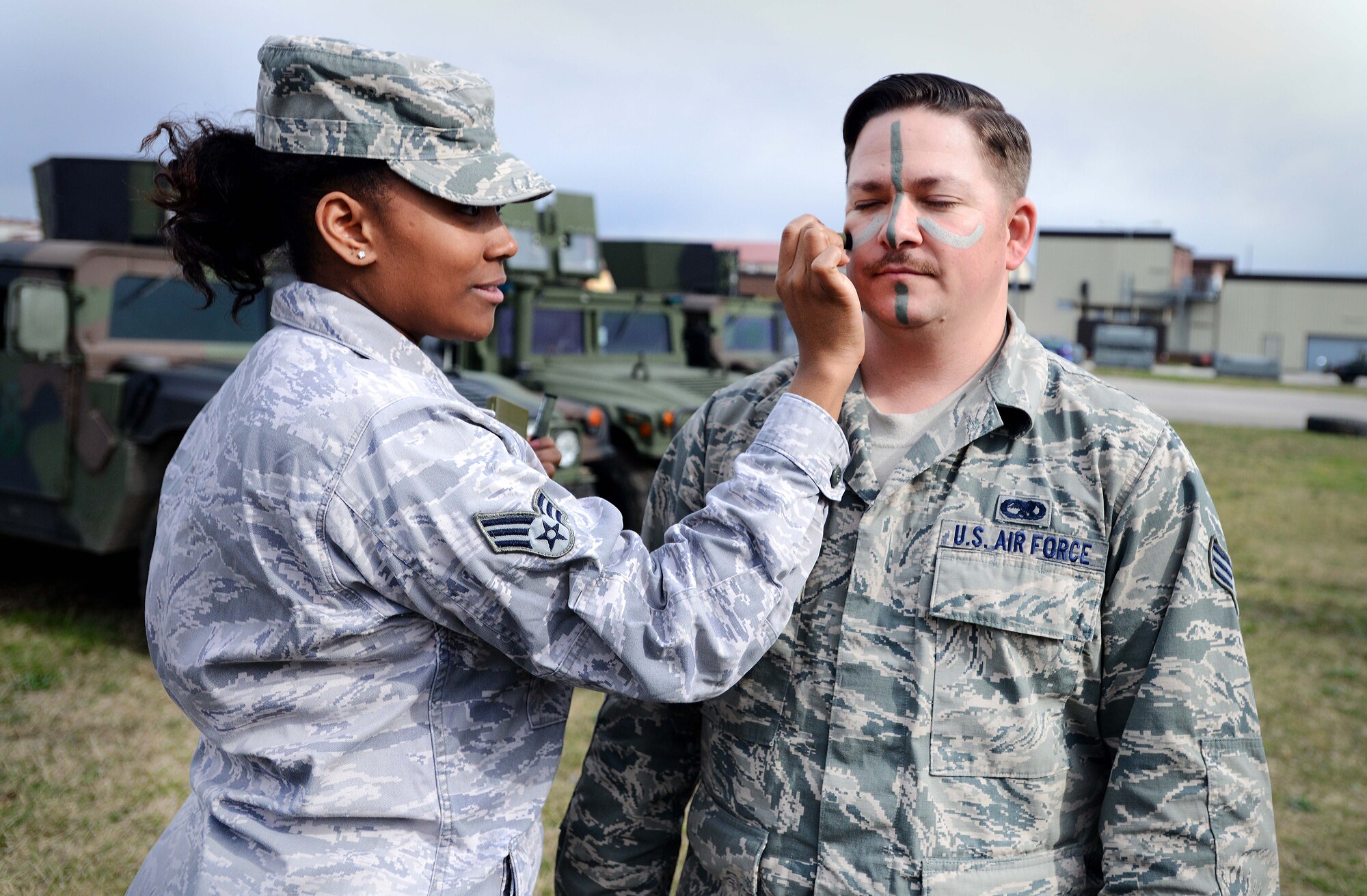 Senior Airman Tamekqua Smith, Aviano Airman Leadership School student, applies face paint on Senior Airman Joseph Archuleta’s, ALS student, face before a combat challenge, March 24, 2014, at Aviano Air Base, Italy. Students from ALS class 14-C participated in strenuous physical fitness challenges while being encouraged from various first sergeants around the base. (U.S. Air Force photo/Airman 1st Class Deana Heitzman)  