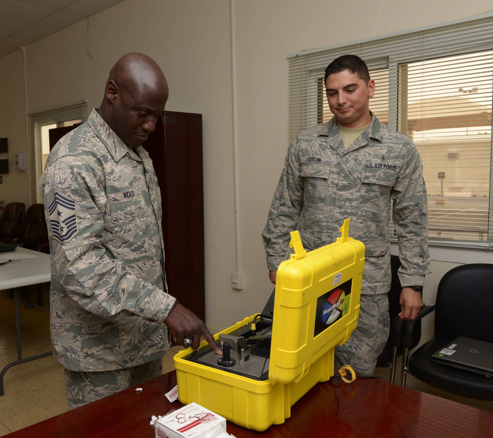 Staff Sgt. Thomas Leguin briefs Chief Master Sgt. Rory Wicks on hazardous material identification system at Al Udeid Air Base, Qatar, Mar. 25, 2014. The HazMat ID system is used to identify unknown liquids, solids, and powders. Wicks is the 379th AEW command chief assigned here and a Kinston, N.C., native. Leguin is the the 379th Expeditionary Medical Operation Squadron bioenvironmental element equipment custodian, deployed from Travis Air Force Base, Calif., and a New Orleans, La., native.(U.S. Air Force photo/Senior Airman Hannah Landeros)