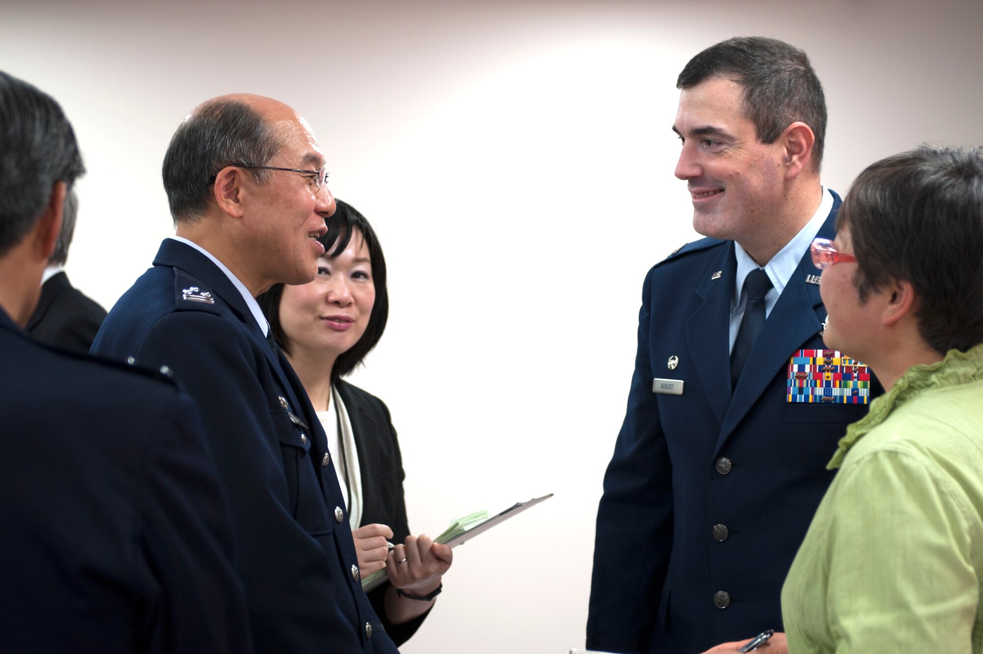 Col. Mark August, 374th Airlift Wing commander, speaks with Col. Shizuo Kashiwase, Japan Air Self-Defense Force, Operations Support Wing commander, following a ceremony March 26, 2014, at Yokota Air Base, Japan. The JASDF Defense Operations Group, located at Yokota, was redesignated as the Operations Support Wing. "I believe that our relationship will continue to grow and expand," August said in his speech. "Yokota is a strategic center of gravity and a critical element of our two nations' commitment to maintaining regional stability."