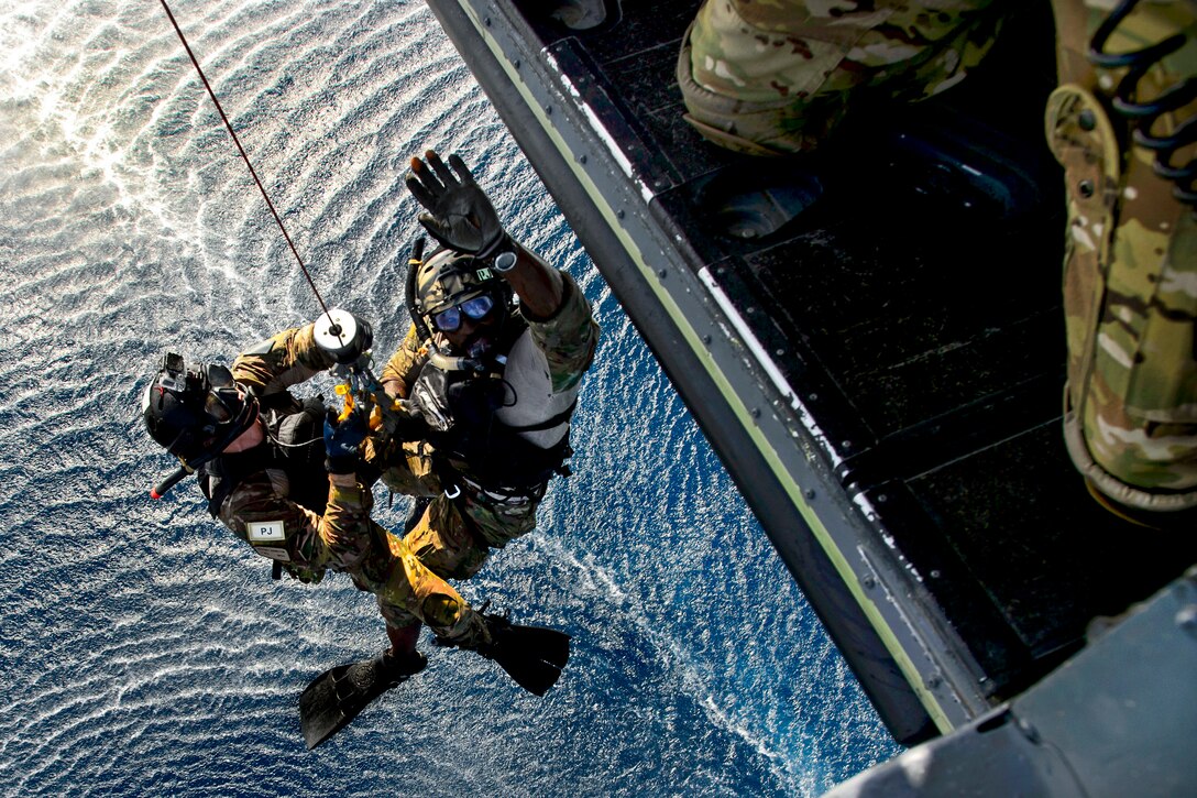 An HH-60 Pave Hawk helicopter hoists U.S. Air Force pararescuemen during a water rescue exercise near Camp Lemonnier, Djibouti, March 20, 2014. The pararescuemen are assigned to the 82nd Expeditionary Rescue Squadron. The training helps airmen stay proficient in water rescue skills.