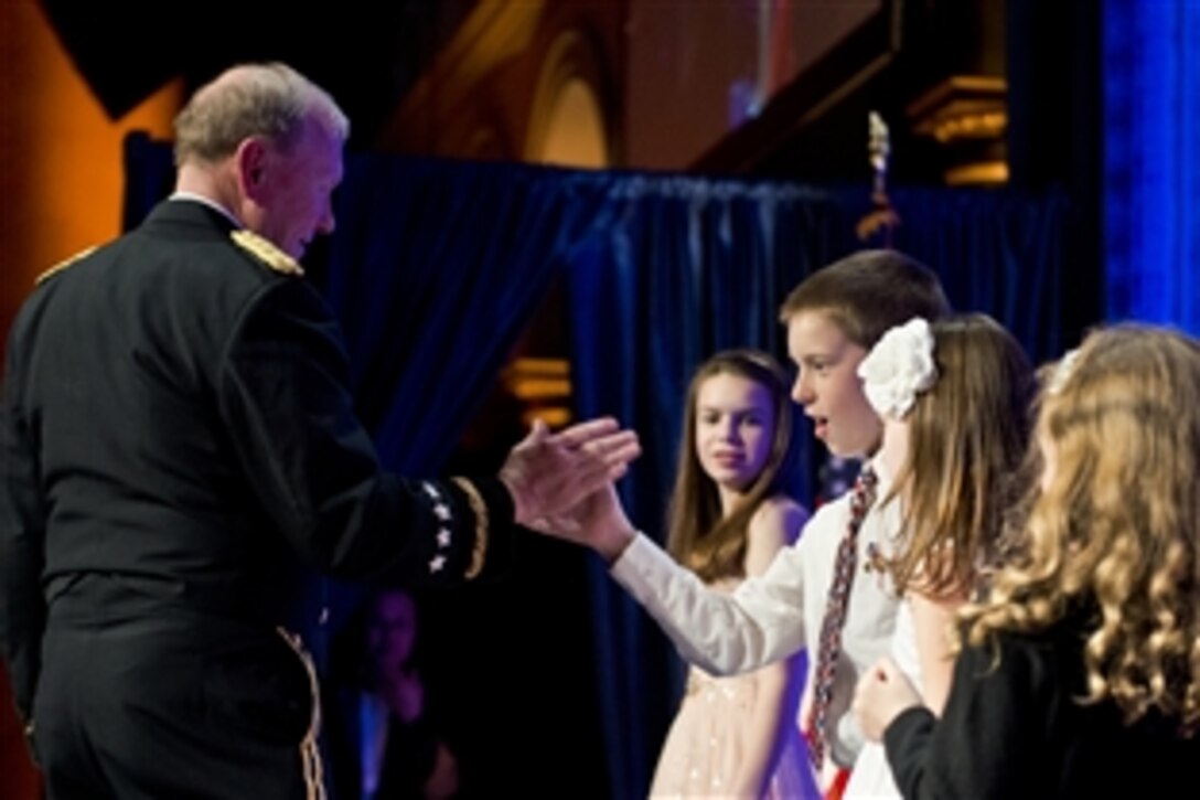 Army Gen. Martin E. Dempsey, chairman of the Joint Chiefs of Staff, high-fives a surviving child during the 2014 Tragedy Assistance Program for Survivors Honor Guard Gala at the National Building Museum in Washington, D.C., March 27, 2014.
