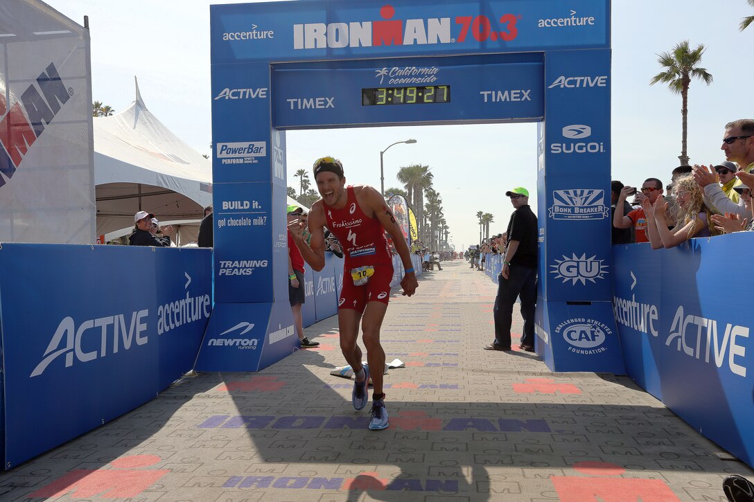 Jan Frodeno celebrates as he sets the new course record and finishes first at the IRONMAN 70.3 California Oceanside on March 29, 2014. Frodeno finished first with an official finish time of 3:49:25, he is also an Olympic triathlon gold medalist. The IRONMAN 70.3 is a 1.2-mile swim transitioning into a 56-mile bike ride followed by a 13.1-mile run to the finish line. The race draws competitors from all over the world. The course starts in Oceanside Harbor and follows the coast making its way to northern Camp Pendleton before looping southward through the base back to the Oceanside Pier area and the finish line. This year’s men’s champion was Jan Frodeno, a German native and an Olympic gold medalist, beating the defending champion American Andy Potts by only a few minutes. 

The top three men’s finishers are German Jan Frodeno taking first with a time of 3:49:25, American Andy Potts taking second with a 3:52:18, and German Sebastian Kienle taking third with a time of 3:53:21. The top three woman’s finishers are Canadian Heather Wurtele taking first with a time of 4:13:12, American Heather Jackson taking second place with a time of 4:14:15, and American Meredith Kessler taking third with a time of 4:19:52.
