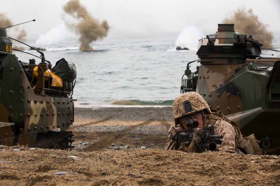 U.S. Marine with Golf Company, 2d Battalion, 3rd Marines, 13th Marine Expeditionary Unit provides cover for amphibious assault vehicle during rehearsal of landing and amphibious recon for Ssang Yong 14 at Dokseok-ri in Pohang, Republic of Korea March 29, 2014. Exercise Ssang Yong is conducted annually in the Republic of Korea (ROK) to enhance interoperability between U.S. and ROK forces by performing a full spectrum of amphibious operations while showcasing sea-based power projection in the Pacific. (U.S. Marine Corps Photo by Cpl. Sara A. Medina, III MEF Combat Camera/Released)