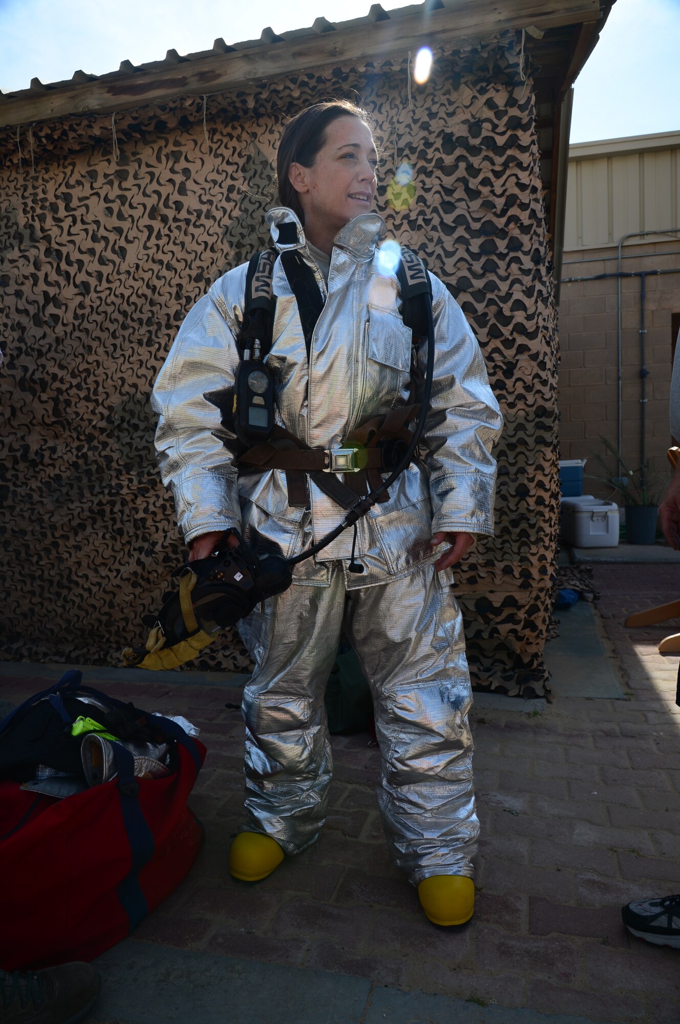 Lt. Col. Carol Miller, the 386th Expeditionary Mission Support Group deputy commander, prepares herself prior to extinguishing a fire during a burn trainer event at an undisclosed location in Southwest Asia. The event allowed senior leaders to gain a better understanding for firefighter duties while deployed to The Rock. Miller is deployed from Luke Air Force Base, Ariz. (U.S. Air Force photo by Senior Airman Desiree W. Moye)