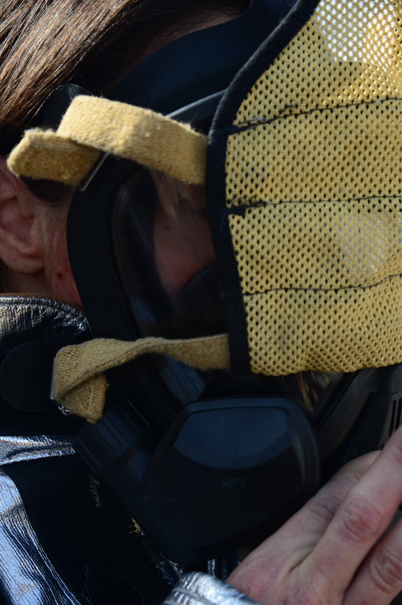 Lt. Col. Carol Miller, the 386th Expeditionary Mission Support Group deputy commander, dons her firfighter gas mask prior to extinguishing a fire during a burn trainer event at an undisclosed location in Southwest Asia. The event allowed senior leaders to gain a better understanding for firefighter duties while deployed to The Rock. Miller is deployed from Luke Air Force Base, Ariz. (U.S. Air Force photo by Senior Airman Desiree W. Moye)