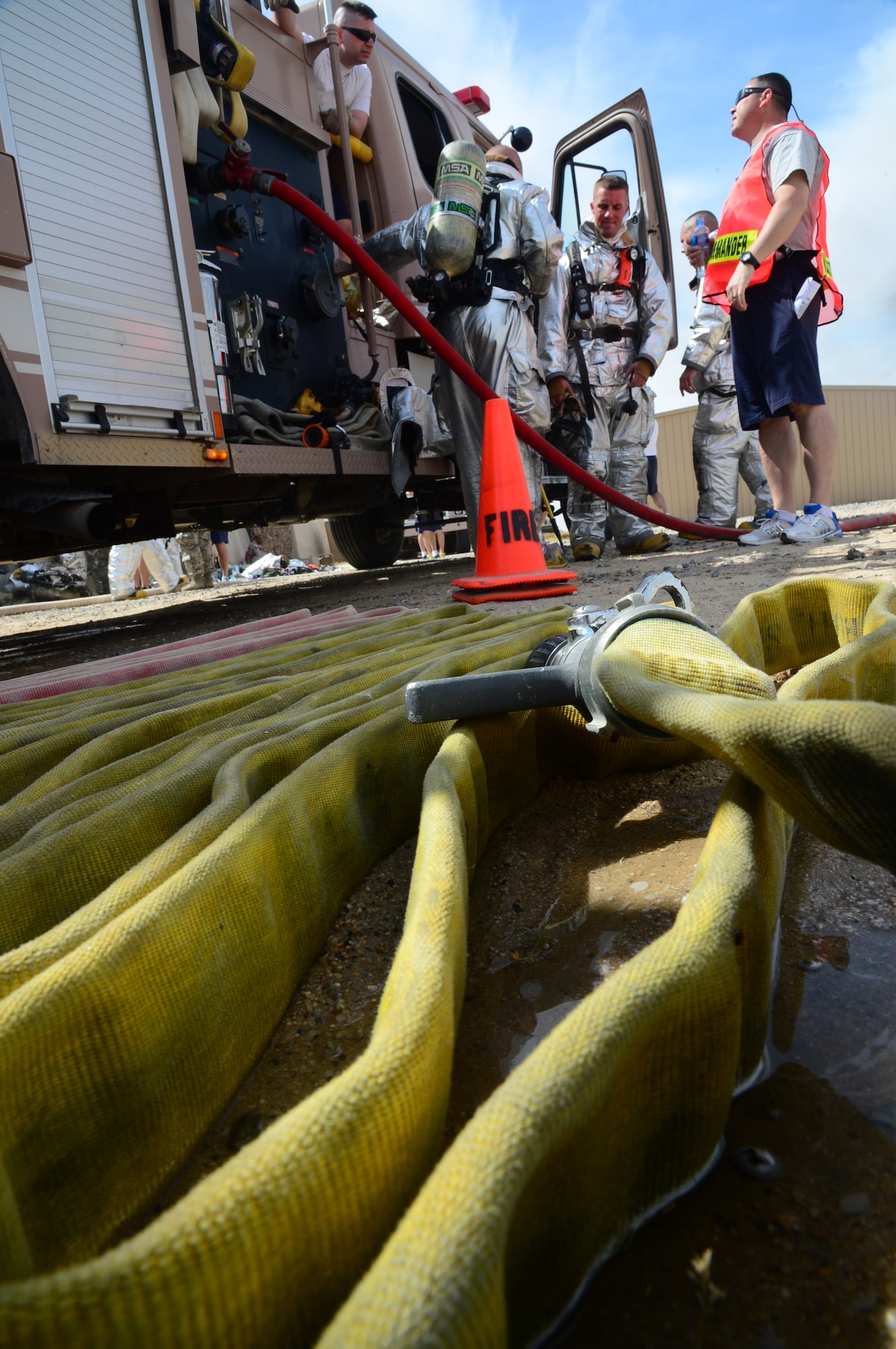 Firefighters assigned to the 386th Expeditionary Civil Engineer Squadron, standby for a burn trainer event at an undisclosed location in Southwest Asia. Burn Trainer allows senior leaders to gain a better understanding for firefighter duties while deployed to The Rock. (U.S. Air Force photo by Senior Airman Desiree W. Moye)
