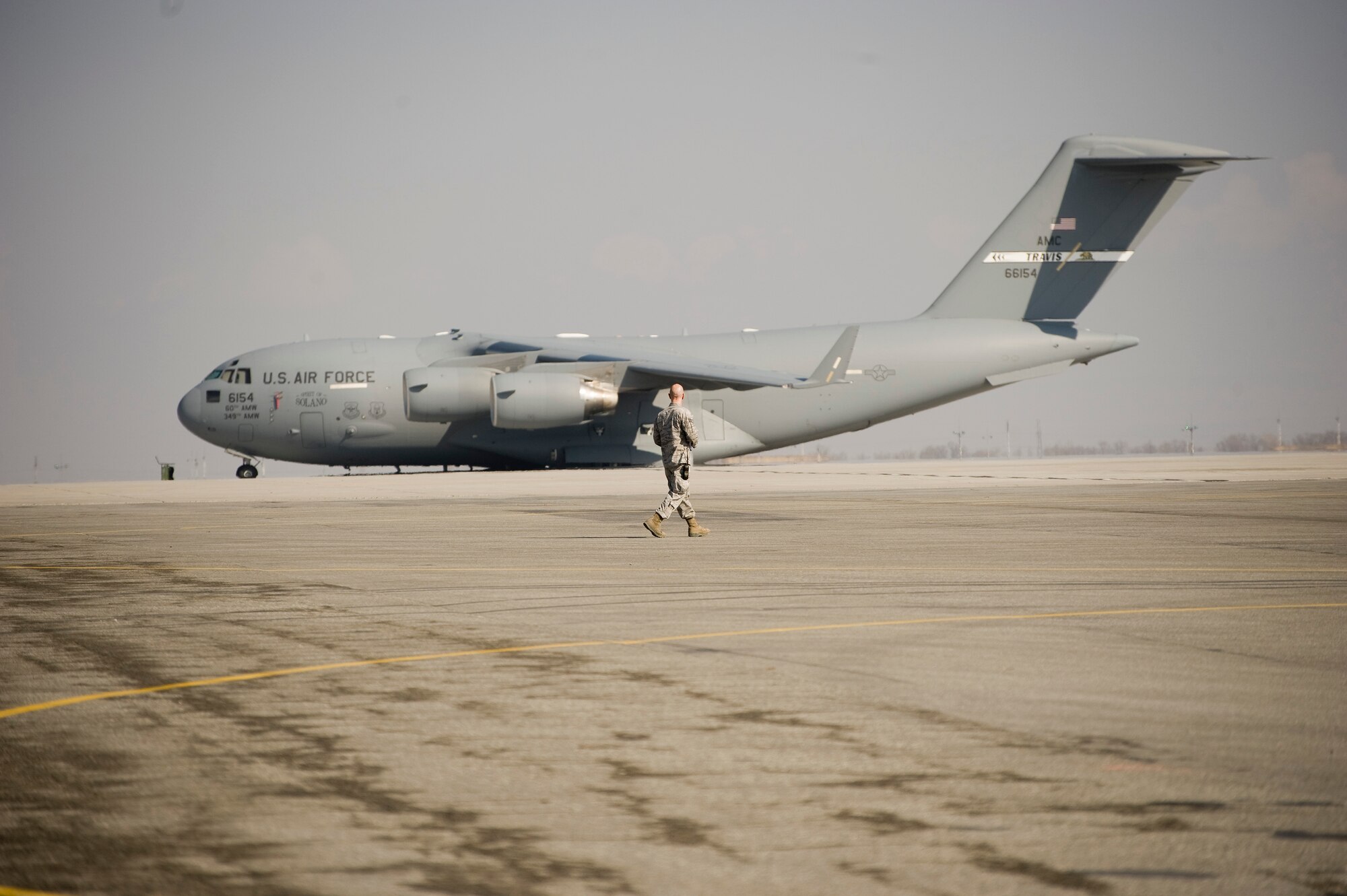 A 376th Expeditionary Logistics Readiness Squadron Airman walks to a C-17 Globemaster III preparing to load cargo on the aircraft at Transit Center at Manas, Krygyzstan, March 28, 2014.  The 376th Air Expeditionary Wing has tons of cargo to ship as part of its scheduled closure by July 10, 2014. (U.S. Air Force photo/Lt Col Max Despain)
