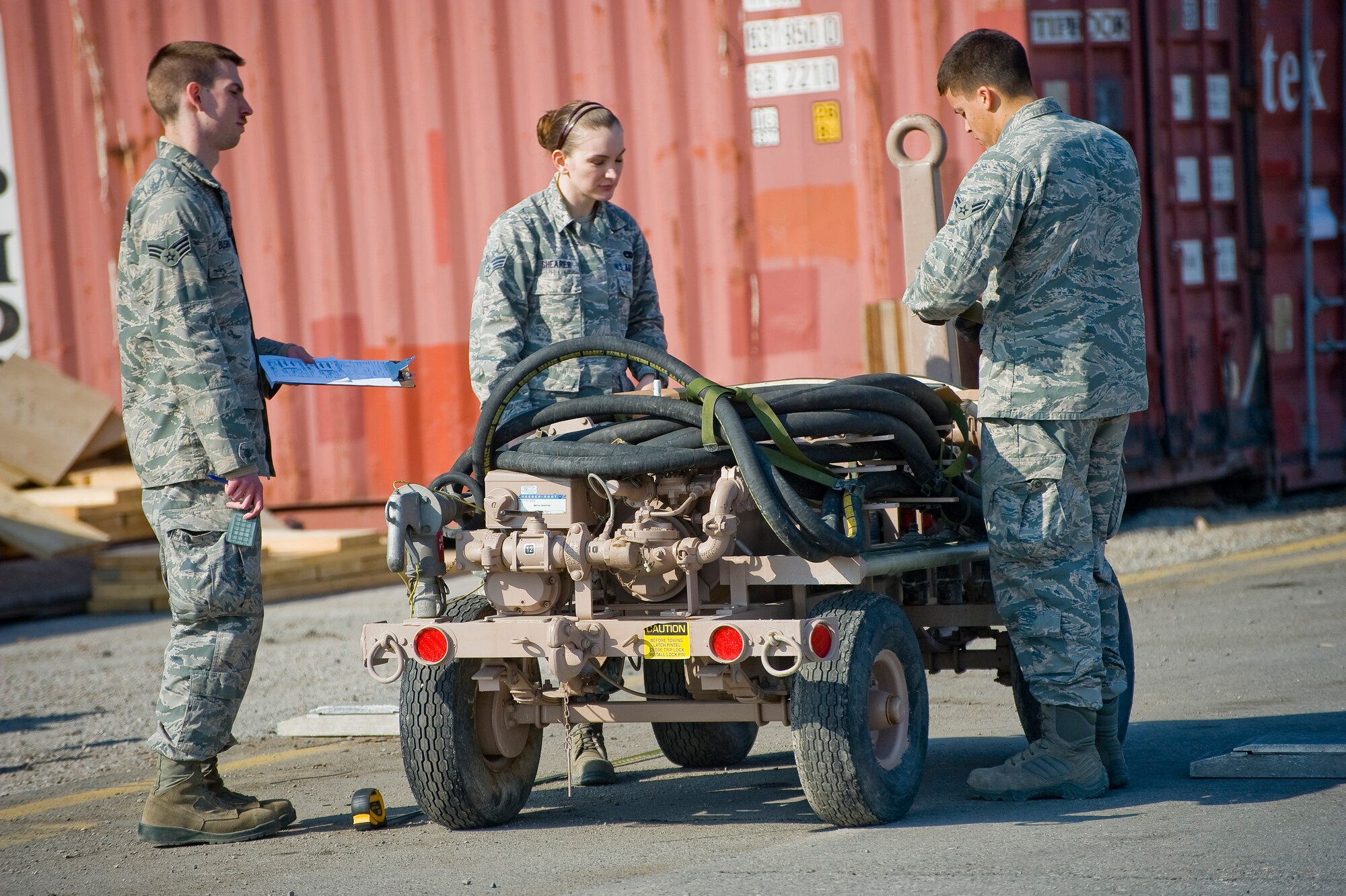 Airmen from the 376th Expeditionary Logistics Readiness Squadron calculate the center of balance for a pumping station at Transit Center at Manas, Kyrgyzstan, March 28, 2014. Senior Airman Alex Bushway deployed from Spangdahlem AB in Germany and originally from West Branch, Mich. records information on a clipboard while Senior Airman Andrea Shearer, deployed from Luke AFB, Ariz. from Clay City, Ky. marks the cargo with duct tape.  Airman First Class Richard Morffi deployed from Luke AFB, a native of Brandon, Fla., helps with the marking. (U.S. Air Force photo/Lt Col Max Despain) 