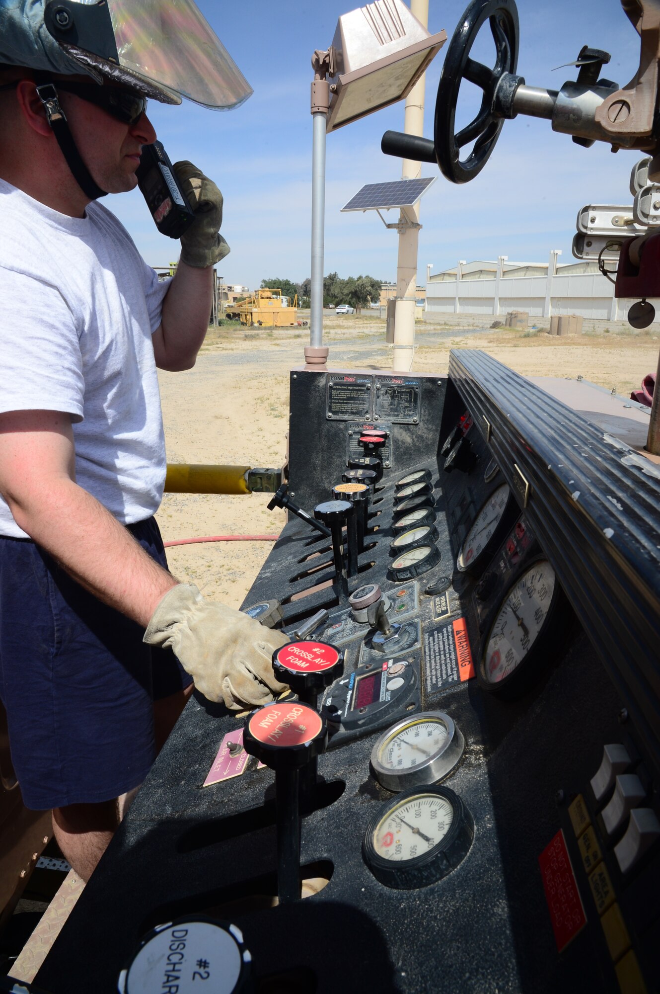 Staff Sgt. Derrick Dimitris, 386th Expeditionary Civil Engineer Squadron fire fight and driver operator, handles the water pressure gage panel during a burn trainer event at an undisclosed location in Southwest Asia. Burn Trainer allows senior leaders to gain a better understanding for firefighter duties while deployed to The Rock. (U.S. Air Force photo by Senior Airman Desiree W. Moye)