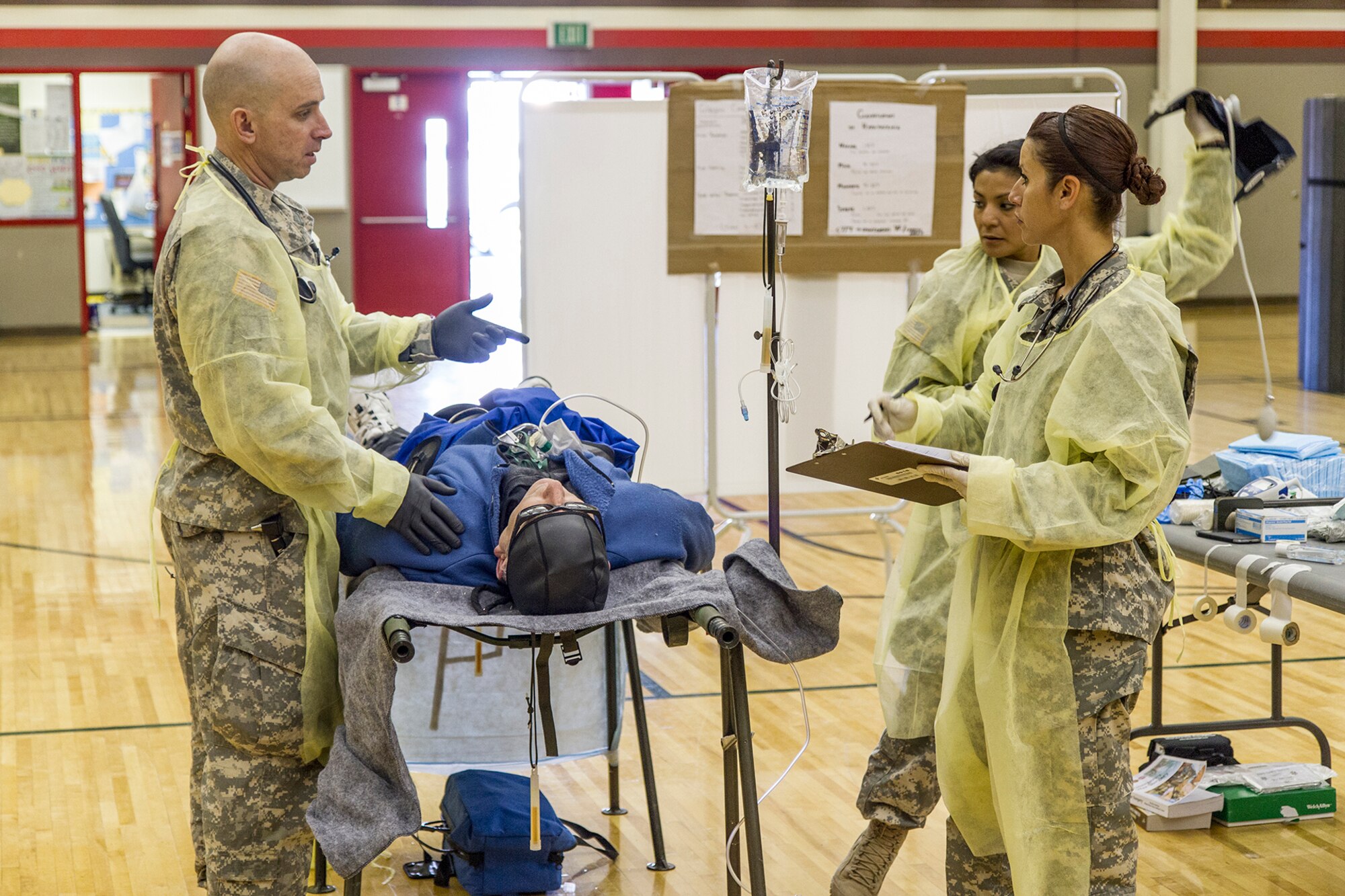 Capt. Eric Olson, Sgt. Bianca Lujan-Dart, and Spc. Elma Kuczora with the Arizona Army National Guard 996 Area Support Medical Company out of Tempe Ariz. work at the alternate care site during exercise Alaska Shield 14 here, March 29, 2014. The team of medical specialist work together to treat and care for role playing civilian patients that could not be treated at the local hospital. Alaska Shield 14 is an exercise that involves state, federal, military, and local agencies, designed to test the response and coordination of the disaster modeled after the 1964 earthquake and subsequent tsunami that devastated much of South Central Alaska including the city of Valdez. (U.S. Army photo by Sgt. Benjamin John)