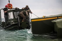 Marines battle heavy sea conditions to assemble an Improved Ribbon Bridge during new equipment training at Camp Schwab Feb. 7. The IRB consists of two components, a ramp bay, which forms the end of the bridge, and the interior bay, forming the center. The Marines are with 9th Engineer Support Group, 3rd Marine Logistics Group