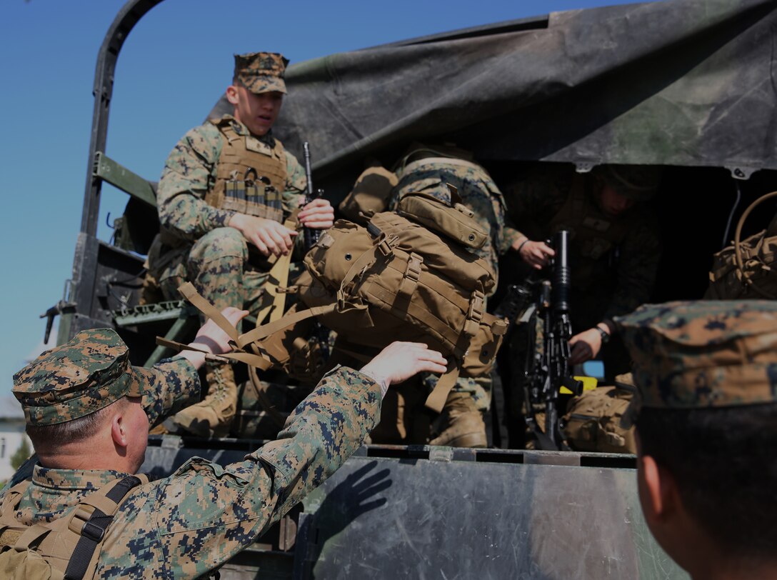 Corporal Benjamin Kirwin, mortarman, Weapons Company, 3rd Battalion, 8th Marines, assigned to Black Sea Rotational Force, watches as Sergeant Jason Tarleton, mortarman, 3rd Battalion 8th Marines, assigned to Black Sea Rotational Force, tosses his assault pack onto a 7-ton truck during a contingency response drill.  Contingency response drills are designed to train Marines to be ready at a moment’s notice.  Black Sea Rotational Force 14 is a task force of Marines and sailors with the mission to sustain positive relationships with partner nations uphold regional stability and increase military operational capabilities while also proving the ability for rapid crisis response in the Black Sea, Balkan and Caucasus regions of Eastern Europe. (Official Marine Corps photo by Staff Sgt. Tanner M. Iskra, 2nd Marine Division Combat Camera, Black Sea Rotational Force/Released)