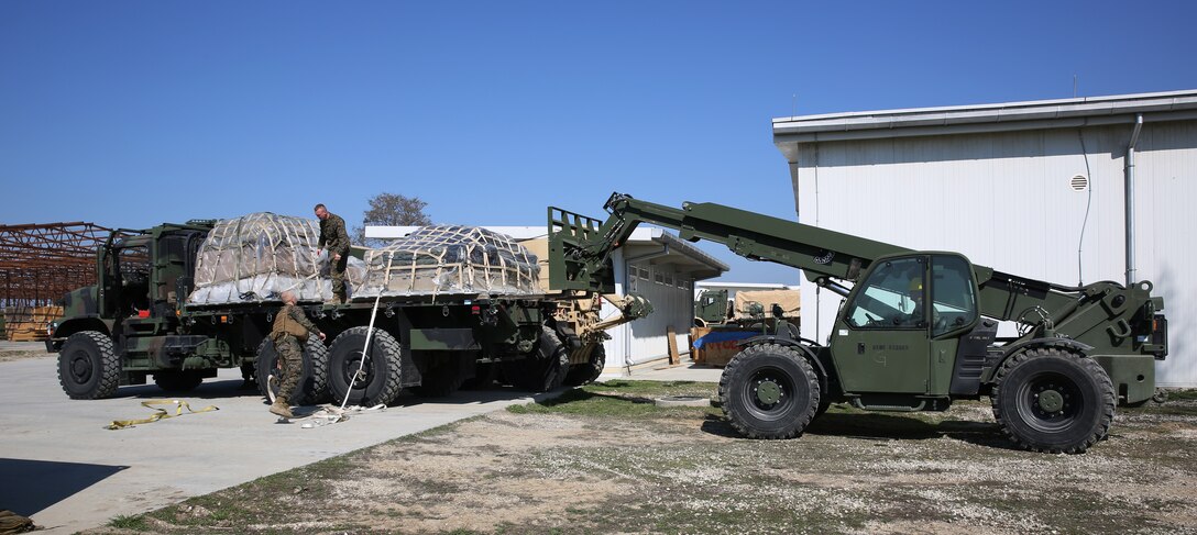 Corporal Vincent Metzler, engineer equipment operator, 3rd Battalion, 8th Marines, assigned to Black Sea Rotational Force offloads a palette on a 7-ton truck with a military millennium vehicle during a contingency response drill.  Contingency response drills are designed to train Marines to be ready at a moment’s notice.  Black Sea Rotational Force 14 is a task force of Marines and sailors with the mission to sustain positive relationships with partner nations uphold regional stability and increase military operational capabilities while also proving the ability for rapid crisis response in the Black Sea, Balkan and Caucasus regions of Eastern Europe. (Official Marine Corps photo by Staff Sgt. Tanner M. Iskra, 2nd Marine Division Combat Camera, Black Sea Rotational Force/Released)