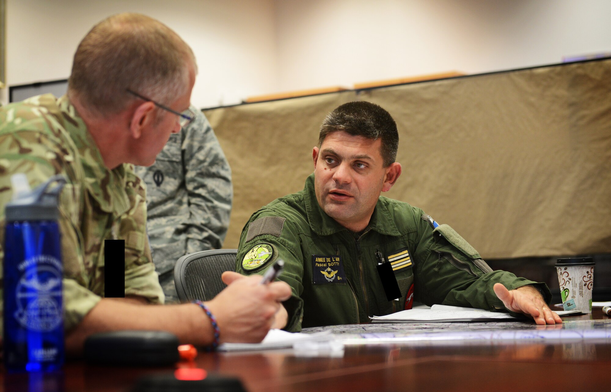 Squadron Leader Gordon Ferguson from the U.K. and LCL Pascal Sotty from France, plan the tri-lateral exercise, Tonnerre Lightning, with U.S. Air Force pilots and 603rd Air and Space Operations Center planning teams on March 27, 2014 at Ramstein Air Base, Germany. The exercise is the first in a series of semi-annual exercises between the NATO countries to improve interoperability and communication in the event of a real-world scenario. This first exercise was conducted off of the English coast and focused on strengthening communication between all agencies involved. (U.S. Air Force photo/Staff Sgt. Ryan Crane) 