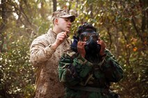 Lance Cpl. Brandon Smith, a chemical, biological, radiological and nuclear defense specialist with CBRN Platoon, Combat Logistics Regiment 27, 2nd Marine Logistics Group helps a Dreher High School Navy Junior Reserve Officer Training Corps cadet with a gas mask during a tour aboard Marine Corps Base Camp Lejeune, N.C., March 27, 2014. The cadets tested their mask’s abilities to seal off contamination while allowing them the ability to still complete physically-demanding tasks.
