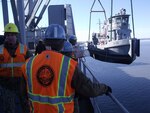 A U.S. Army tugboat is unloaded from the USNS Mendonca, a large cargo ship, during Alaska Shield 2014 in Anchorage, Alaska, March 27 2014. 