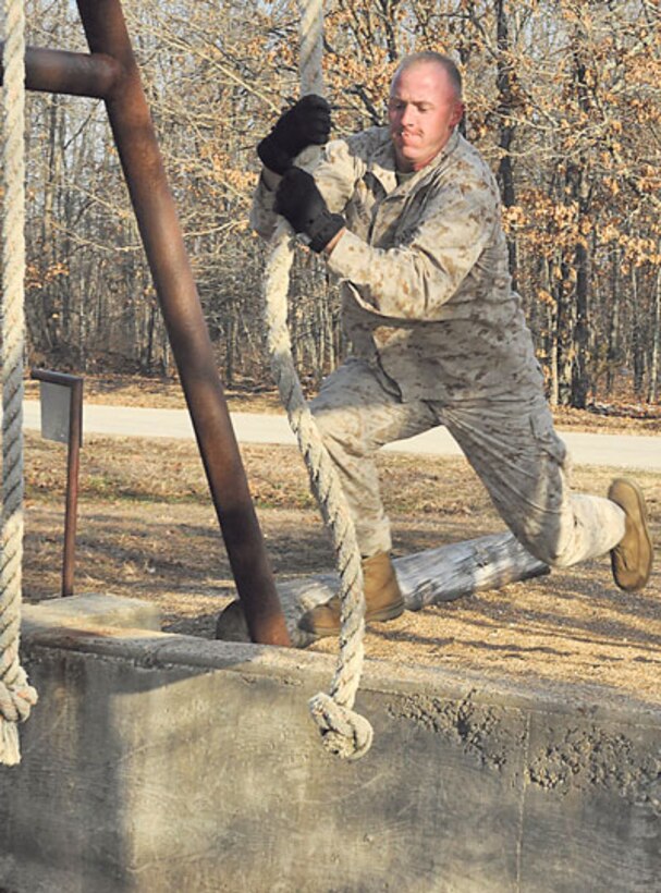 Marine Sgt. Michael Baldwin, Marine Corps Detachment, swings across a pit during the Physical Endurance Confidence course event.