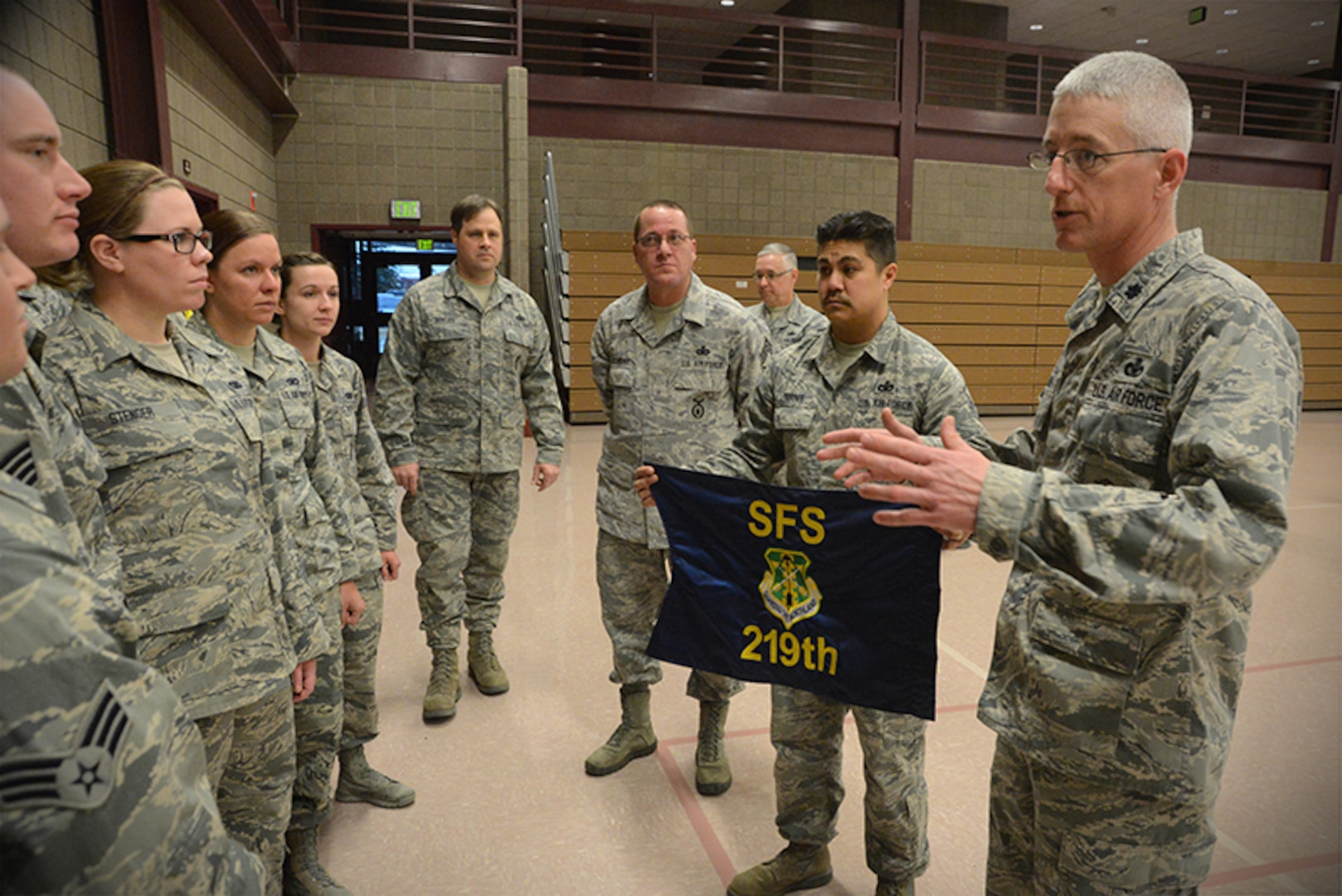 Lt. Col. Tad Shauer, the 219th Security Forces Commander, right,speaks to deploying unit members as Master Sgt. Larry Torres, the 219th Security Forces first sergeant, prepares to present a unit flag during a send-off ceremony at the Minot Armed Forces Reserve Center, Minot N.D., March 14, 2014.