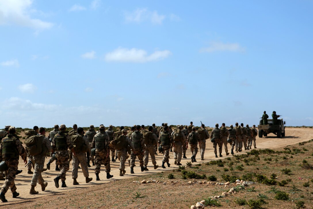 A multinational brigade of military policemen comprised Royal Moroccan soldiers, U.S. Marines, soldiers and airmen stage prior to walking to the designated training range for scheduled nonlethal weapons enforcement and escalation-of-force operations during African Lion 14 in Tifnit training area, Morocco March 30. Nonleathal weapons employment and escalation-of-force operations are an integral part of military operations to prevent the loss-of-life while maintaining civil disorder. During the evolution, Royal Moroccan Armed Forces soldiers, and U.S. military policemen from the Marines, Army and Air Force combined to refine a share their escalation-of-force tactics and procedures while building military partnerships and international friendships. 
