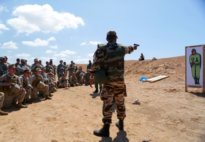 A Royal Moroccan Armed Forces soldier instructs a joint contingent of U.S. Marines, Army soliders, and Air Force airmen during a pistol familiarization during African Lion 14. Nonleathal weapons employment and escalation-of-force operations are an integral part of military operations to prevent the loss-of-life while maintaining civil disorder. During the evolution, Royal Moroccan Armed Forces soldiers, and U.S. military policemen from the Marines, Army and Air Force combined to refine a share their escalation-of-force tactics and procedures while building military partnerships and international friendships.