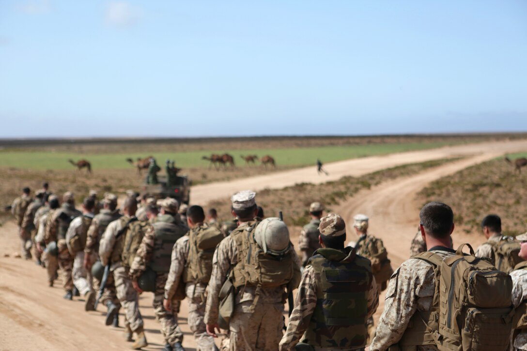 A multinational brigade of military policemen comprised Royal Moroccan soldiers, U.S. Marines, soldiers and airmen stage prior to walking to the designated training range for scheduled nonlethal weapons enforcement and escalation-of-force operations during African Lion 14 in Tifnit training area, Morocco March 30. Nonleathal weapons employment and escalation-of-force operations are an integral part of military operations to prevent the loss-of-life while maintaining civil disorder. During the evolution, Royal Moroccan Armed Forces soldiers, and U.S. military policemen from the Marines, Army and Air Force combined to refine a share their escalation-of-force tactics and procedures while building military partnerships and international friendships. 
