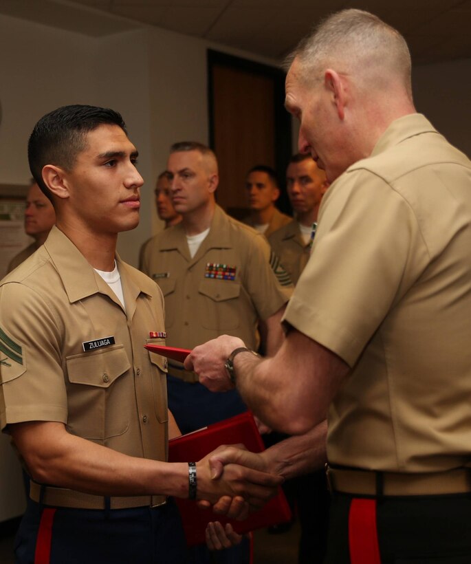Major General Mark A. Brilakis, Commanding 
General, Marine Corps Recruiting Command, presents a Certificate of Commendation to Cpl. Jhon M. Zuluaga, Logistics Non-Commissioned Officer, during a MCRC awards ceremony, here, March 28. Upon completion of three consecutive years of "honorable and faithful service," Zuluaga received his 
Good Conduct Medal, in addition to two Certificates of Commendation for
being selected as the NCO of the Year in 2013 for Marine Corps National Capital 
Region Command, and for his outstanding contributions and fundraising
efforts to MCRC's Birthday Ball Committee.

