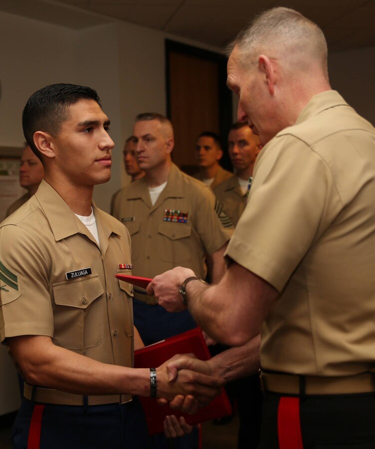 Major General Mark A. Brilakis, Commanding 
General, Marine Corps Recruiting Command, presents a Certificate of Commendation to Cpl. Jhon M. Zuluaga, Logistics Non-Commissioned Officer, during a MCRC awards ceremony, here, March 28. Upon completion of three consecutive years of "honorable and faithful service," Zuluaga received his 
Good Conduct Medal, in addition to two Certificates of Commendation for
being selected as the NCO of the Year in 2013 for Marine Corps National Capital 
Region Command, and for his outstanding contributions and fundraising
efforts to MCRC's Birthday Ball Committee.
