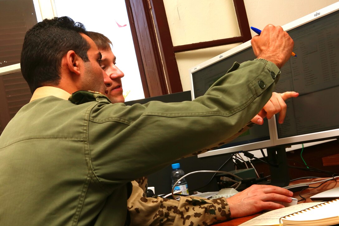 German 2ndLt Christian Neuman, shows a Moroccan  soldier specific points to look at while analizing terrain information during an intelligence capacity building workshop as a part of Exercise African Lion 2014.  Royal Moroccan intelligence personnel teamed up with U.S. Marines and German forces for a week to build understanding of the processes each use to gather information essential to a commander to make informed decisions on the battelfield. 

Exercise African Lion 14 is a multi-lateral and combined-joint exercise between the Kingdom of Morocco, the U.S. and other partner nations designed to strengthen relationships with participating countries by increasing understanding of each nation's military capabilities.  The military-to-military portion of the exercise includes: command-post exercises with humanitarian aid and disaster relief themes; stability operations, such as nonlethal weapons training and respond-to-crisis drills; and an intelligence capability-building workshop.