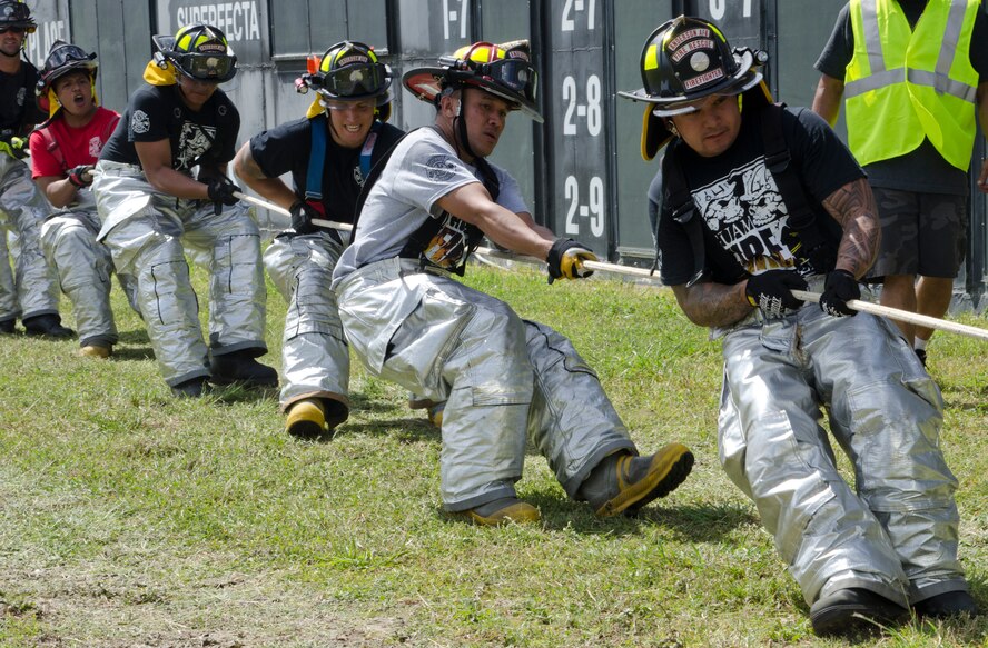 36th Civil Engineer Squadron Fire and Emergency Services members pull a fire truck during the 2014 Guam Firefighter Muster Challenge March 15, 2014, in Tamuning, Guam. The two-day event brought together firefighters from the Guam Fire Department, Commonwealth of the Northern Mariana Islands, Guam International Airport, Andersen Air Force Base and Naval Base Guam to test their skills and build camaraderie. (U.S. Air Force photo by Senior Airman Katrina M. Brisbin/Released)