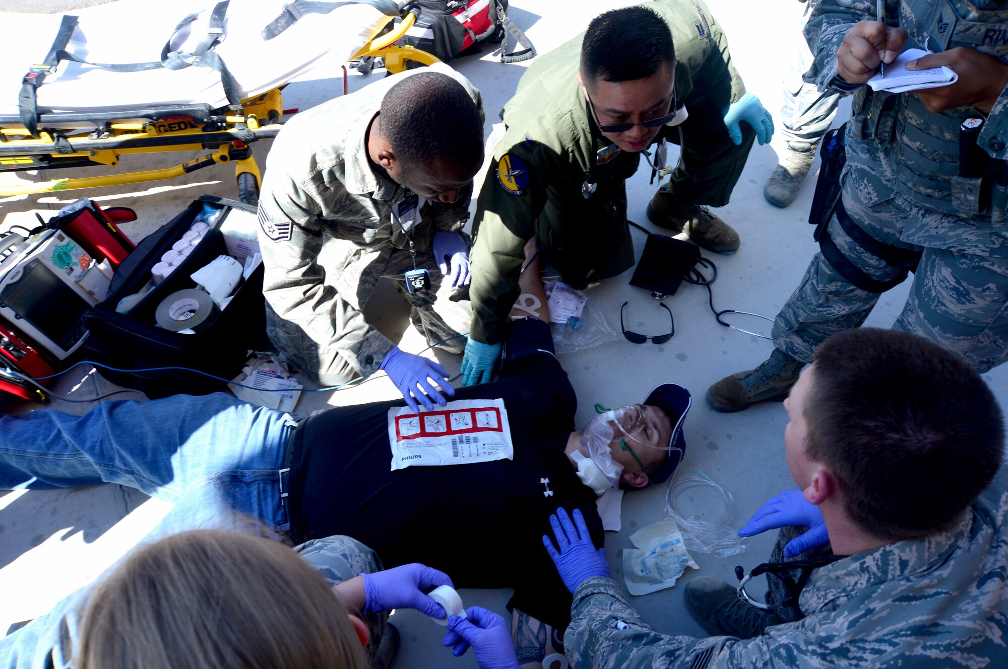 Airmen from various units rush to stabilize a simulated patient with a sucking chest wound during an active shooter exercise at Creech Air Force Base, Nev., March 25, 2014. Simulated injuries during the exercise with Nellis Air Force Base, Nev., were chosen to test the capabilities of medical personnel in preparation for real-world situations. (U.S. Air Force photo by Staff Sgt. N.B./Released)