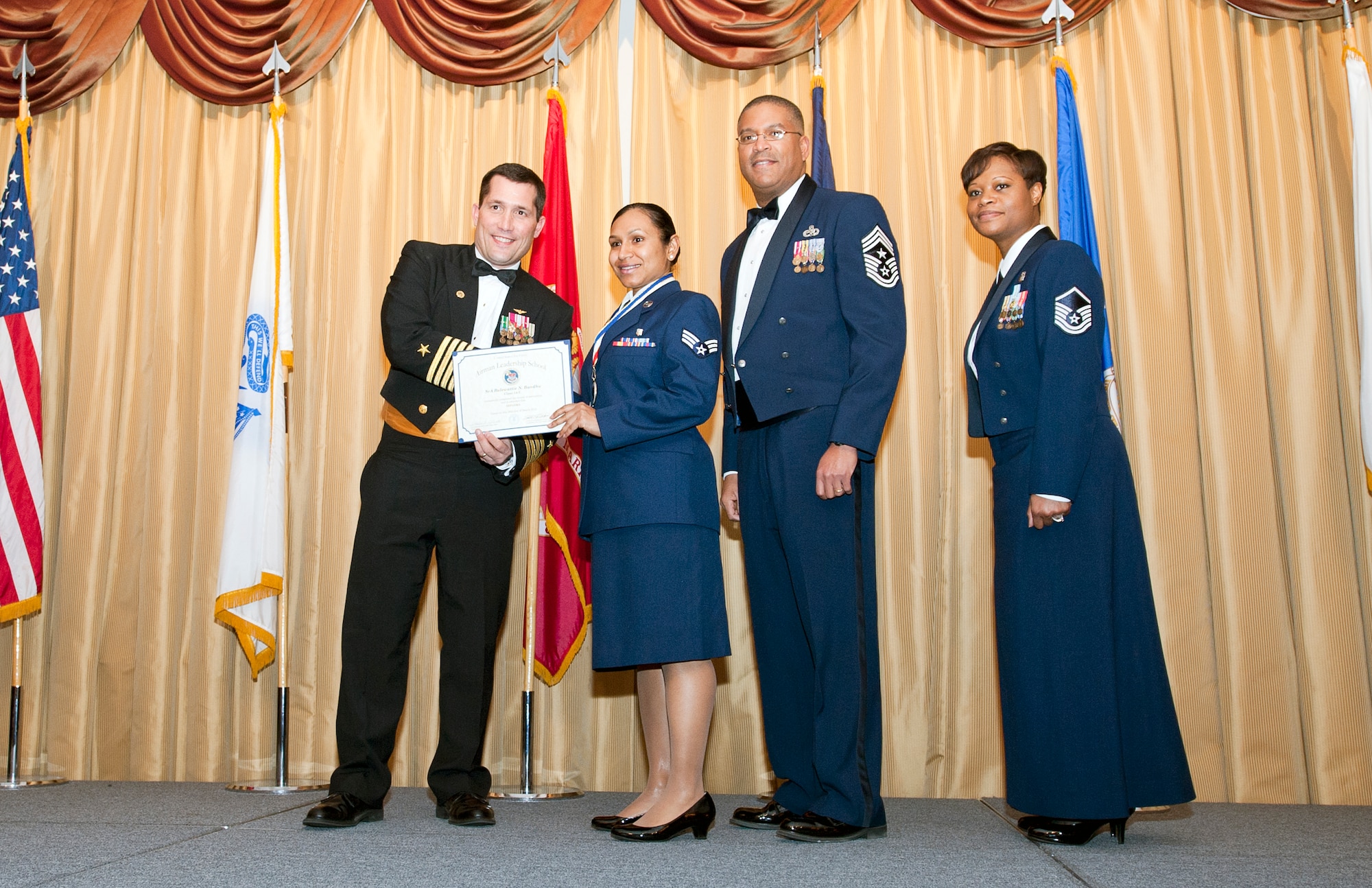Senior Airman Balewattie Bandhu, 514th Aerospace Medicine Squadron, receives her diploma for completing the Kish Airman Leadership School at Tommy B's Community Activities Center, here, March 26. (U.S. Air Force photo/Christian DeLuca).