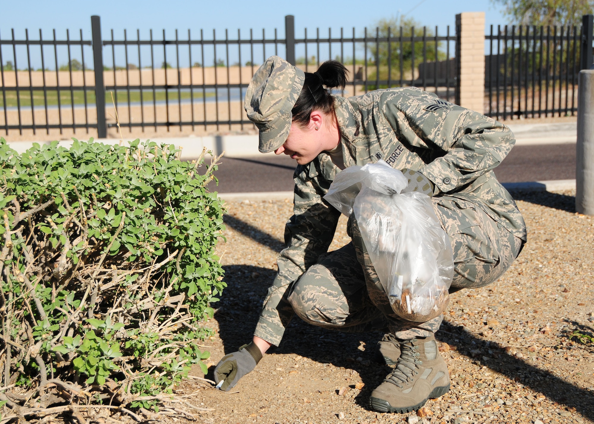 Senior Airman Ashlynd Fine, 944th Aeromedical Staging Squadron medical technician, picks up trash March 22 at the South Gate Visitor Reception Center as part of a community service team member at Luke Air Force Base, Ariz. (U.S. Air Force photo taken by Tech. Sgt. Louis Vega Jr.)