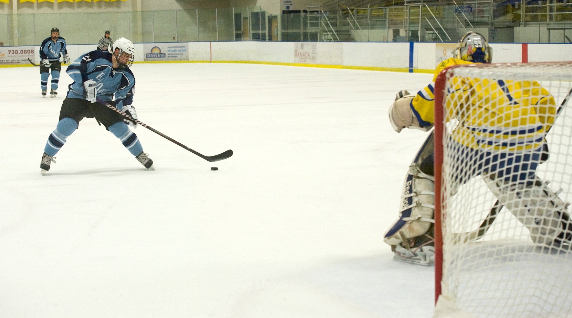 Sam Ernst, Dover Eagles center, skates the puck toward Joe Marshall, Blue Hens goalie, and the net moments before taking a shot during a charity hockey game March 23, 2014, at the Fred Rust Ice Arena on the University of Delaware campus in Newark, Del. Ernst scored three points during the game; one goal and two assists. (U.S. Air Force photo/Airman 1st Class Zachary Cacicia)
