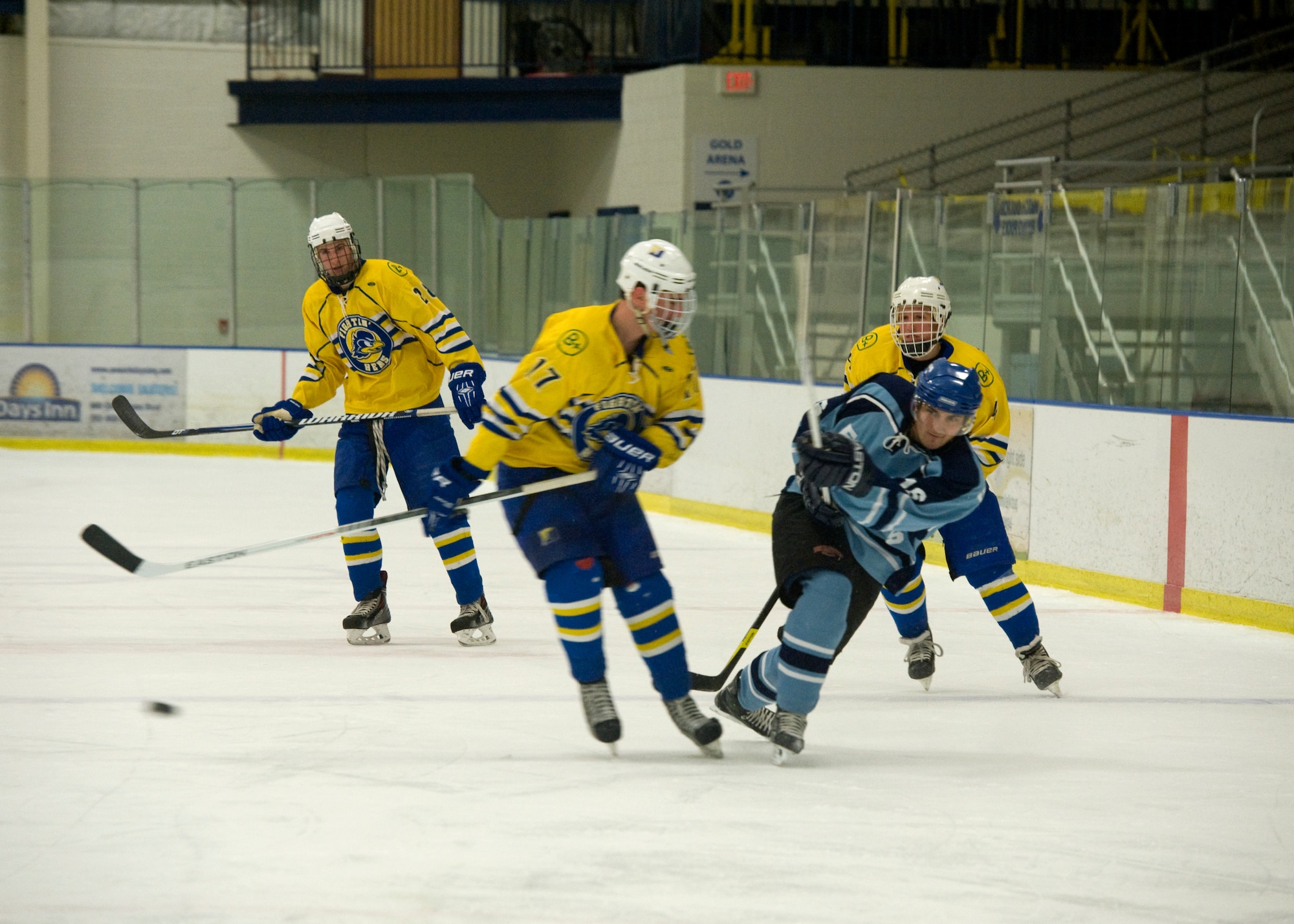 Casey Wheatley, Dover Eagles defenseman, shoots a slap shot past Matthew Goldberg, Blue Hens forward, during a charity hockey game March 23, 2014, at the Fred Rust Ice Arena on the University of Delaware campus in Newark, Del. The Dover Eagles consist of 19 Team Dover Airmen. (U.S. Air Force photo/Airman 1st Class Zachary Cacicia)