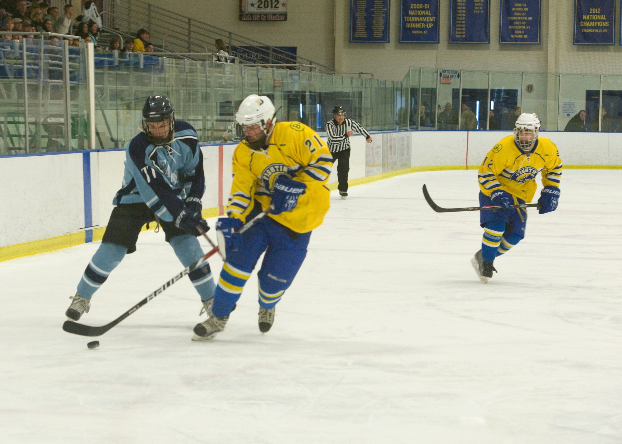 Alec Burgess, Dover Eagles defenseman, and J.P. Aiello, Blue Hens defenseman, battle for the puck during a charity hockey game March 23, 2014, at the Fred Rust Ice Arena on the University of Delaware campus in Newark, Del. This charity hockey game raised $3,200 for the Fisher House Foundation. (U.S. Air Force photo/Airman 1st Class Zachary Cacicia)