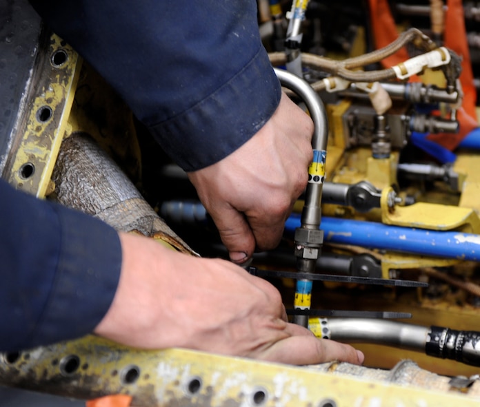 U.S. Air Force Airman 1st Class Andrew Rowlette, 7th Equipment Maintenance Squadron, performs preventative maintenance on a hydraulic line inside of a B-1B Lancer March 27, 2014, at Dyess Air Force Base, Texas. Rowlette installed a protective wrap on the lines to keep them from rupturing during flight. (U.S. Air Force photo by Airman 1st Class Alexander Guerrero/Released)