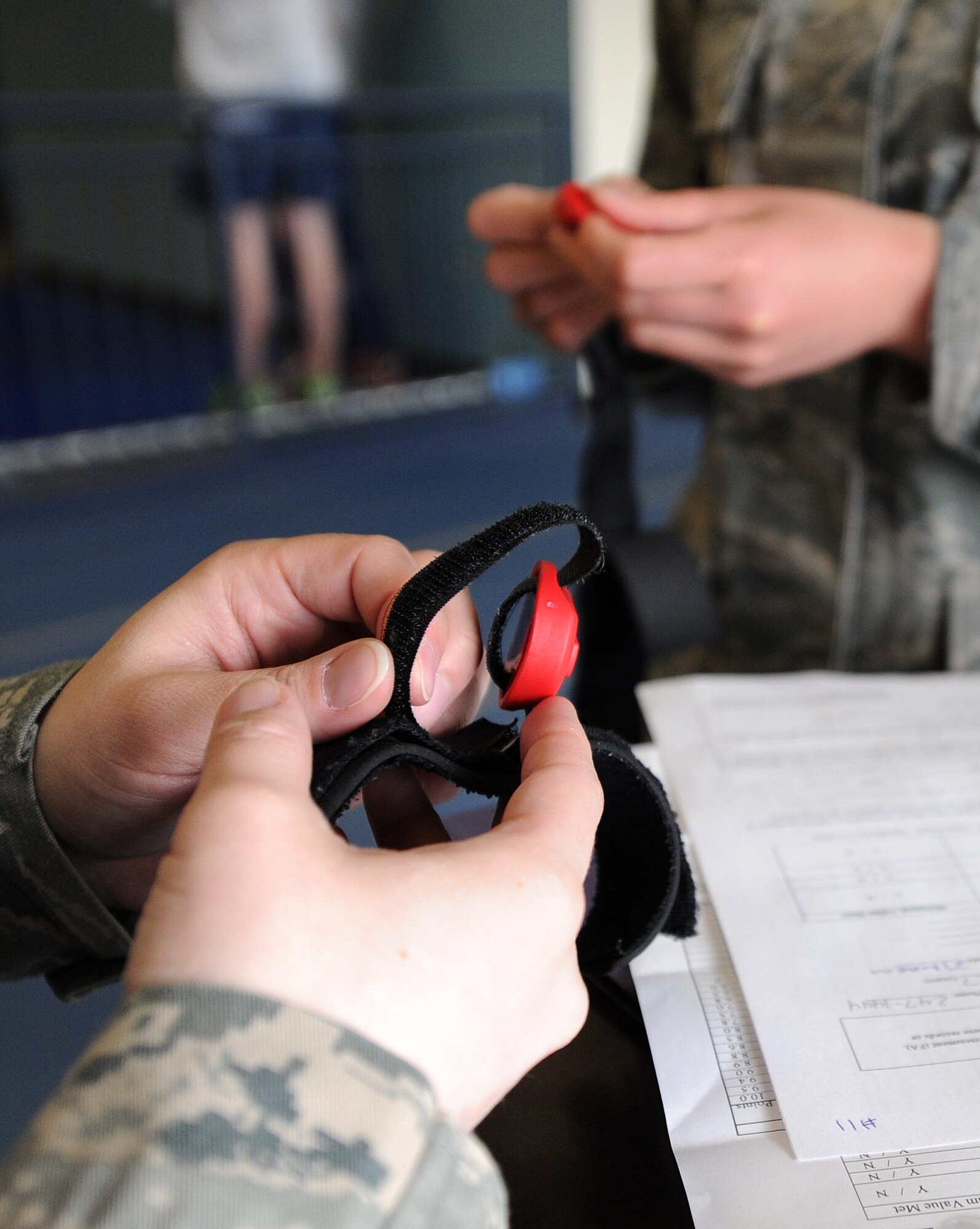 Staff Sgt. Lindsey Griffin sets up the lap counting device for the mile and a half run during the physical fitness test at Fairchild Air Force Base, Wash., March 27, 2014. Griffin is from the 92nd Security Forces Squadron. The device counts the laps and records the runner's time. (U.S. Air Force photo by Airman 1st Class Janelle Patiño/Released)