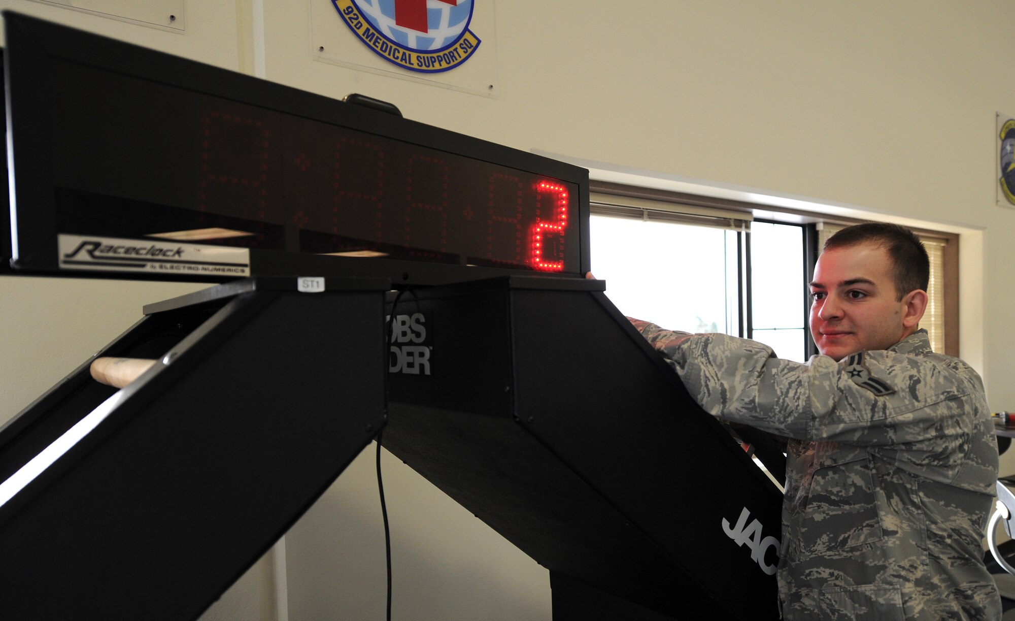 Airman 1st Class Justin Guerreso turns on the countdown clock machine for the mile and a half run during a physical fitness test at Fairchild Air Force Base, Wash., March 27, 2014. Guerreso is from the 92nd Air Refueling Wing Judge Advocate and is currently on training to be a physical training leader. (U.S. Air Force photo by Airman 1st Class Janelle Patiño/Released)
