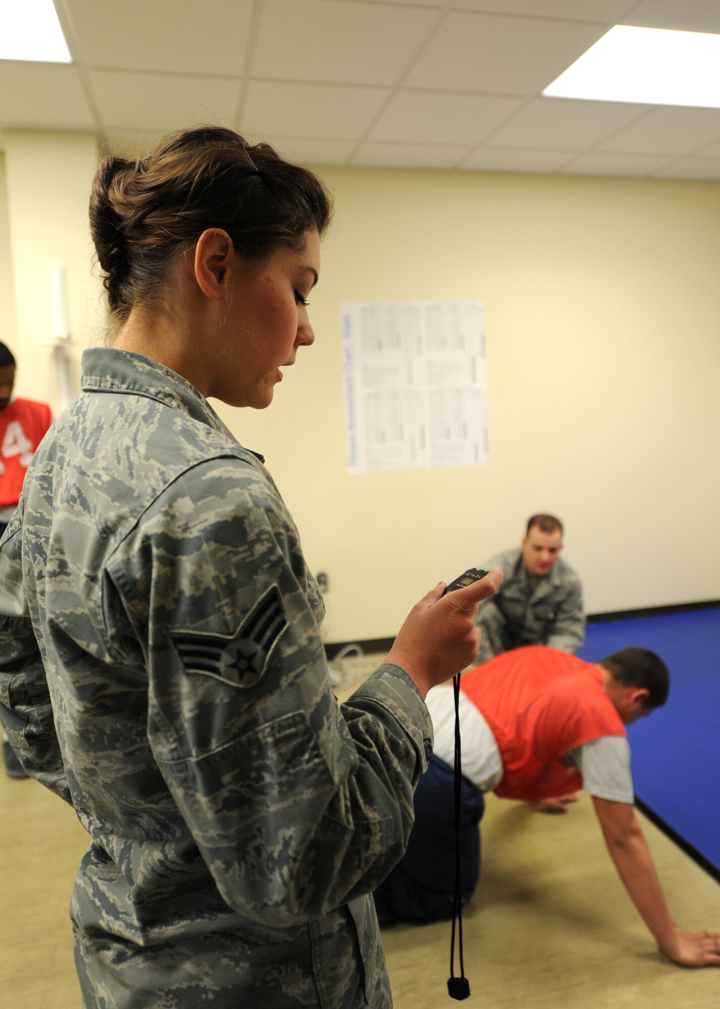 Senior Airman Guinevere Running Wolf times the physical fitness test at Fairchild Air Force Base, Wash., March 27, 2014. Running Wolf is a fitness assessment NCO in charge from the 92nd Force Support Squadron. (U.S. Air Force photo by Airman 1st Class Janelle Patiño/Released)