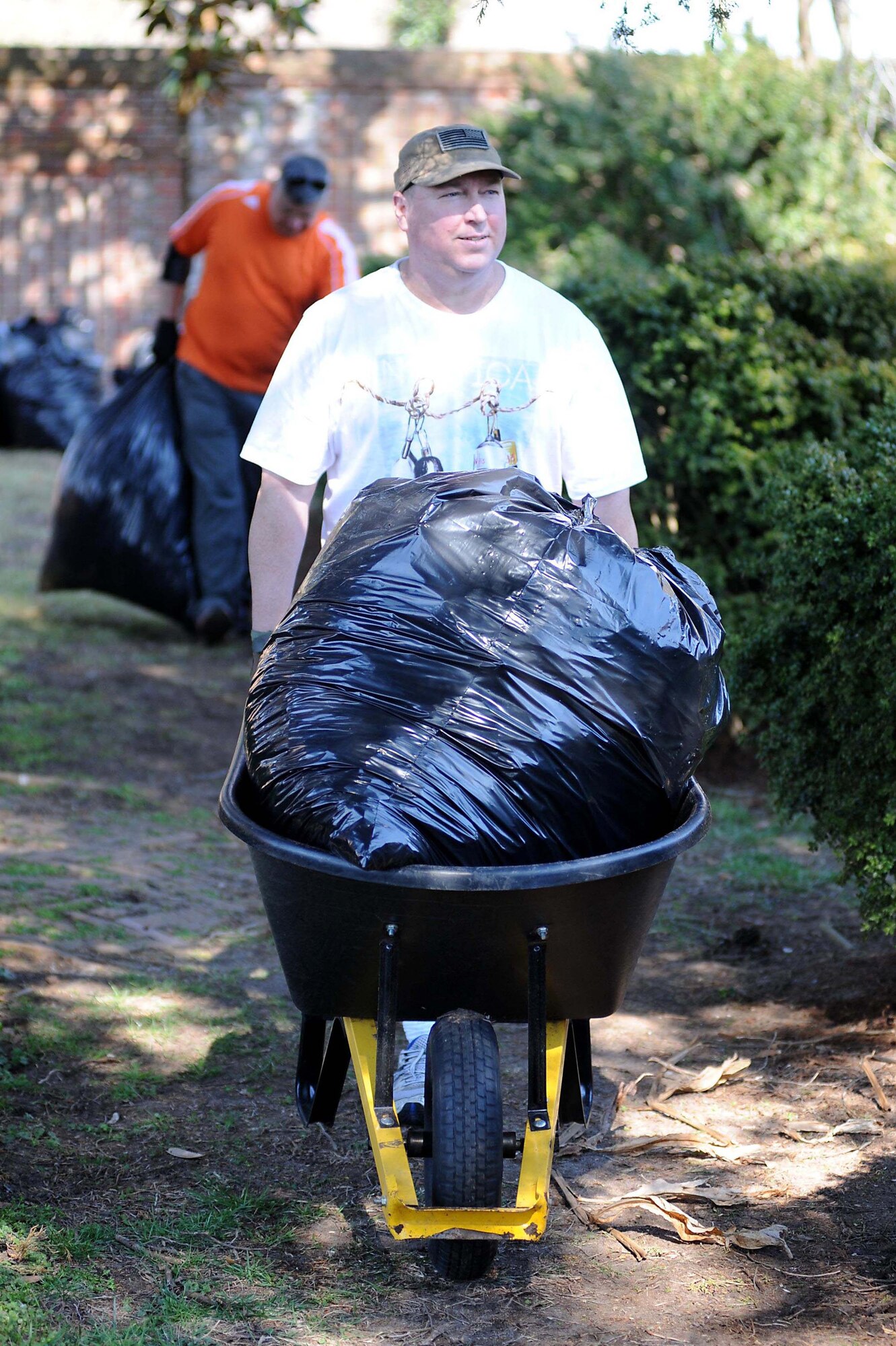 U.S. Army Command Sgt. Maj. Richard Capps, Joint Task Force-Civil Support senior enlisted leader, carries a wheelbarrow with bags full of leaves during an enlisted Service member volunteer event at the Nelson House in Yorktown, Va., March 21, 2014. Eleven enlisted JTF-CS personnel and one civilian volunteered to clean the grounds of the Nelson House by raking and disposing of leaves, laying new mulch, disposing of ground debris and grooming the overall property. (Department of Defense photo by U.S. Air Force Tech. Sgt. Gwendolyn Blakley/Released)