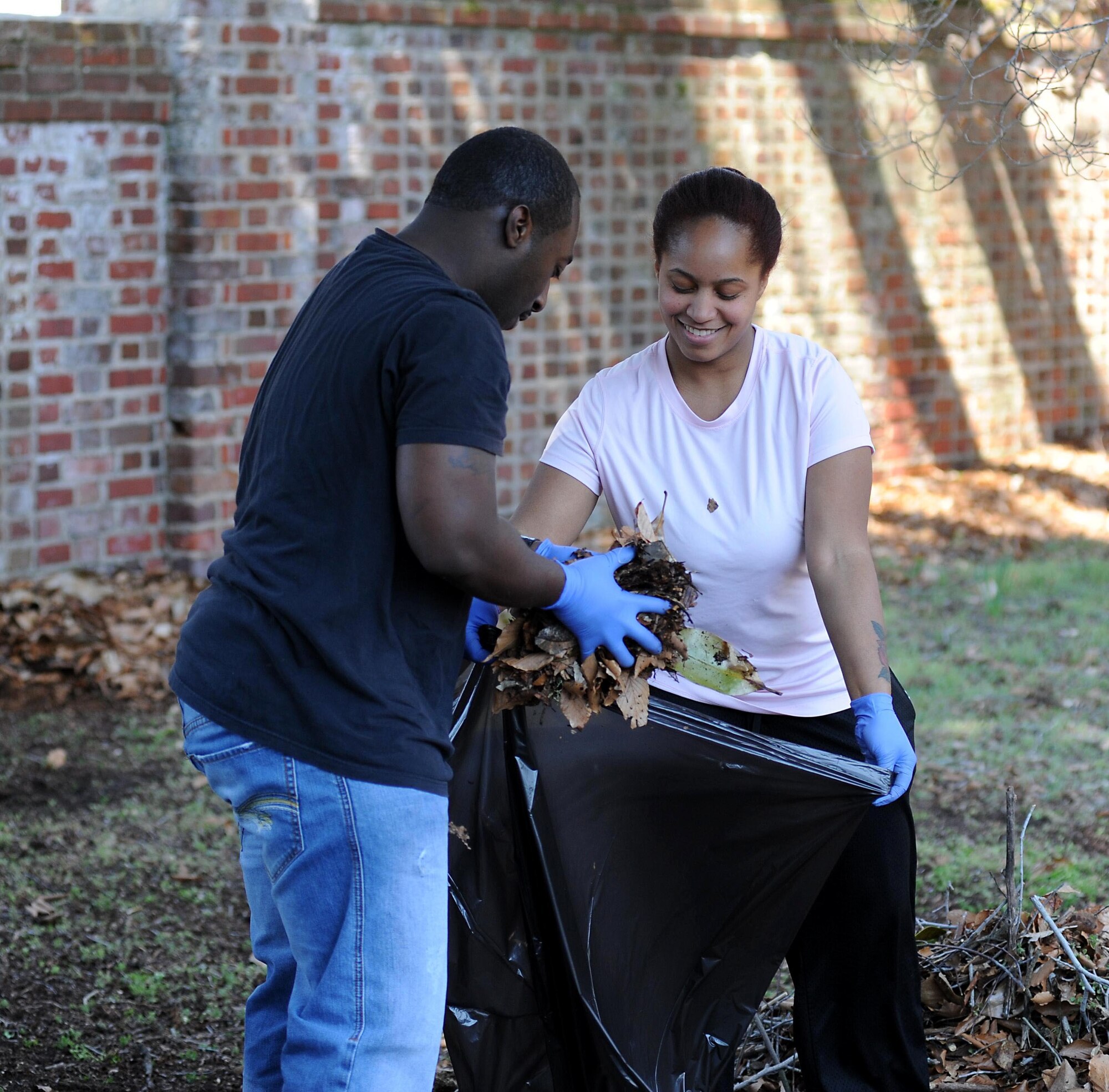 U.S. Navy Petty Officers 2nd Class Craig Beasley and Franchesca Foxx, Joint Task Force Civil Support operations specialists, dispose of leaves during an enlisted Service member volunteer event at the Nelson House in Yorktown, Va., March 21, 2014. The historic Nelson House is the former residence of Thomas Nelson, the fourth governor of Virginia and a signer of the Declaration of Independence. Eleven enlisted JTF-CS personnel and one civilian volunteered to clean the grounds of the Nelson House by raking and disposing of leaves, laying new mulch, disposing of ground debris and grooming the overall property. (Department of Defense photo by U.S. Air Force Tech. Sgt. Gwendolyn Blakley/Released)