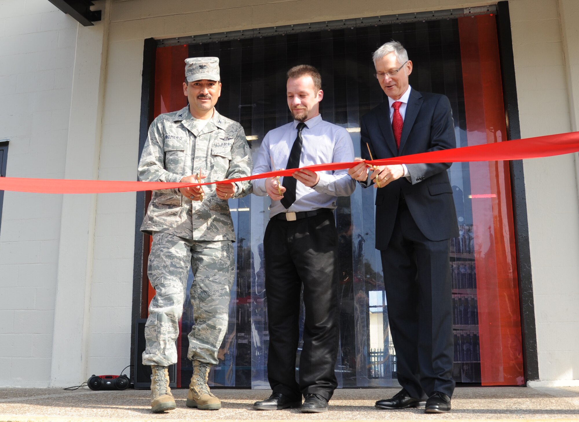 Col. René Romero, 81st Training Wing vice commander, Drew Camire, L.C. industries base supply center store manager, and Jeffrey Hawting, L.C. Industries chief operating officer, cut the ribbon during the Ability One Base Supply Center ribbon cutting ceremony March 27, 2014, at Keesler Air Force Base, Miss.  Supply vending tables were on display for the event. (U.S. Air Force photo by Kemberly Groue)
