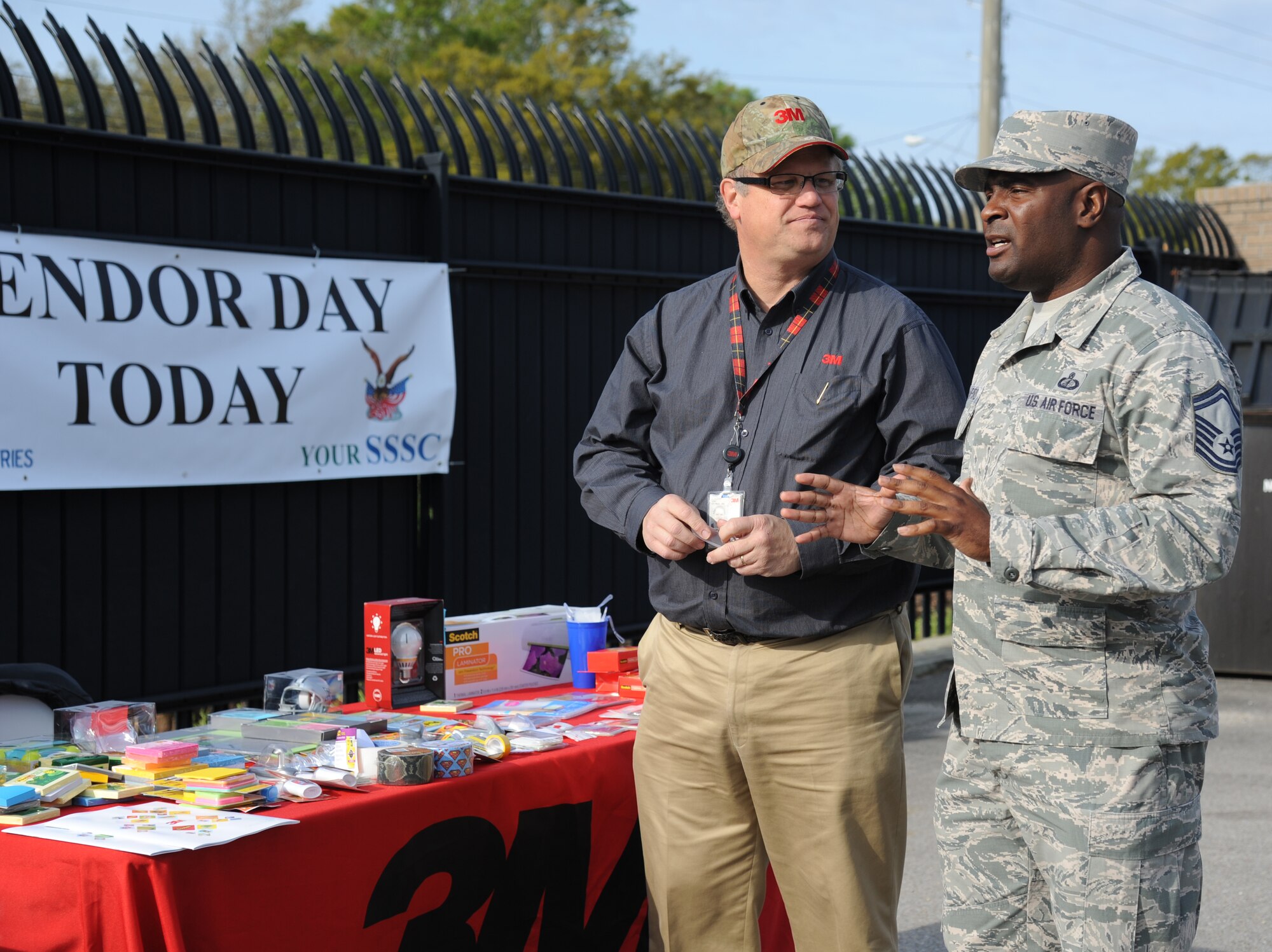 George Foley, government business development manager, and Senior Master Sgt. Donald Crawford, 81st Contracting Squadron, discuss office supply products during the Ability One Base Supply Center grand opening March 27, 2014, at Keesler Air Force Base, Miss. A ribbon cutting ceremony took place and supply vending tables were on display for the event.  (U.S. Air Force photo by Kemberly Groue)
