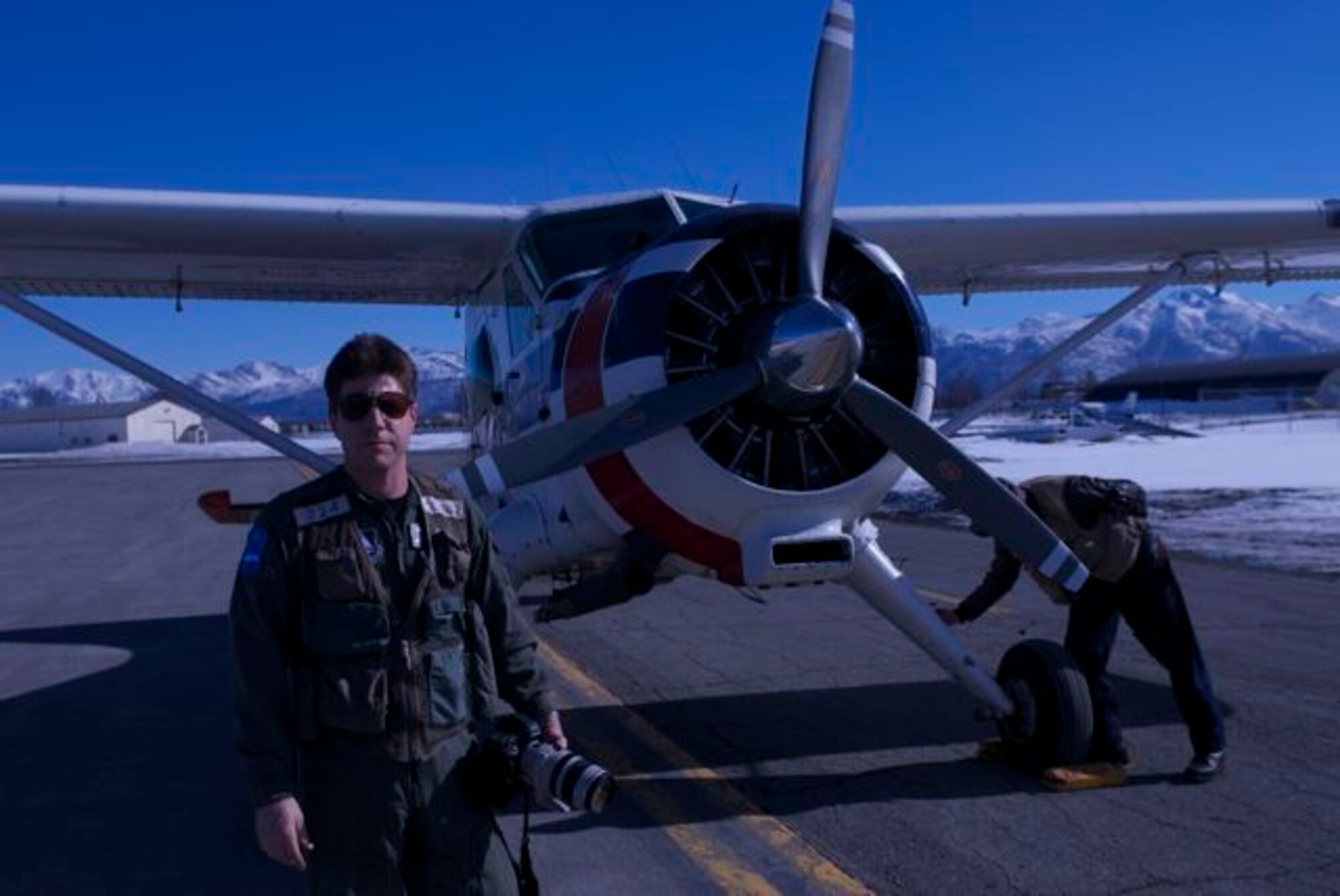 Jeff Morton, a Civil Air Patrol mission observer, is pictured with his camera outside a small cub plane on Joint Task Force Elmendorf-Richardson, Alaska, March 29, 2014. Morton's job is to photograph key energy transportation and drilling facilities in the event of a natural emergency and relay that data to federal authorities for analysis during Alaska Shield. Alaska Shield 14 is an exercise that involves state, federal, military, and local agencies, designed to test response and coordination efforts during a disaster and is modeled after the 1964 earthquake and subsequent tsunami that devastated much of South Central Alaska. (U.S. Army by Spc. Ryan A. Swanson)